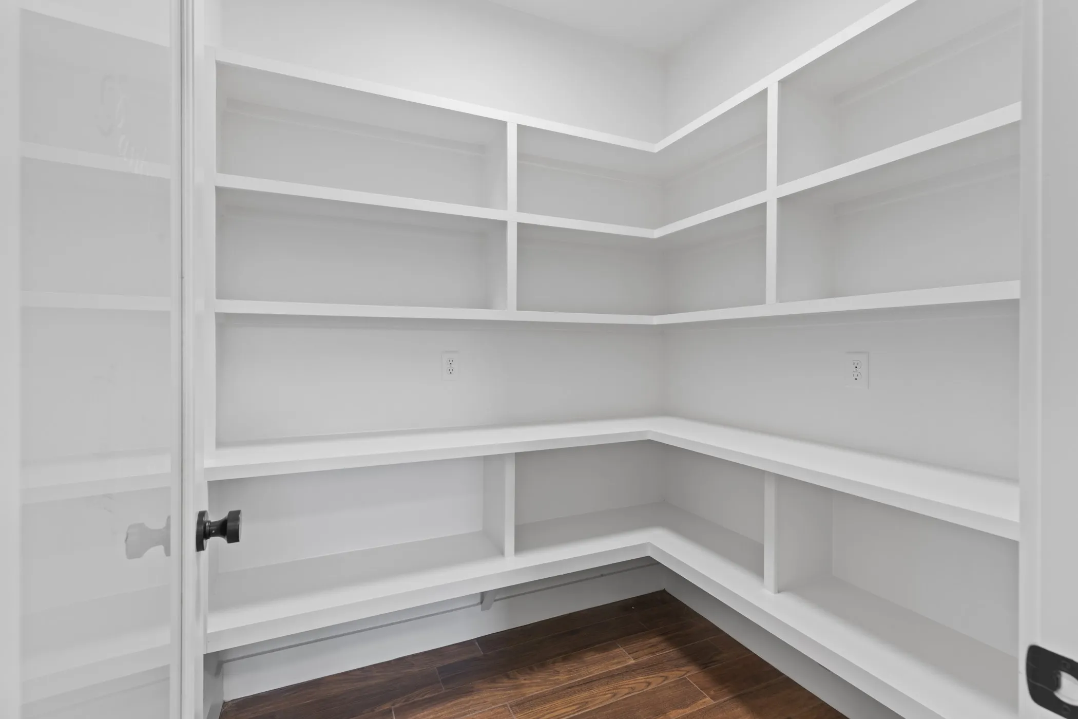 Built-in shelving with multiple storage levels and wood-finish flooring