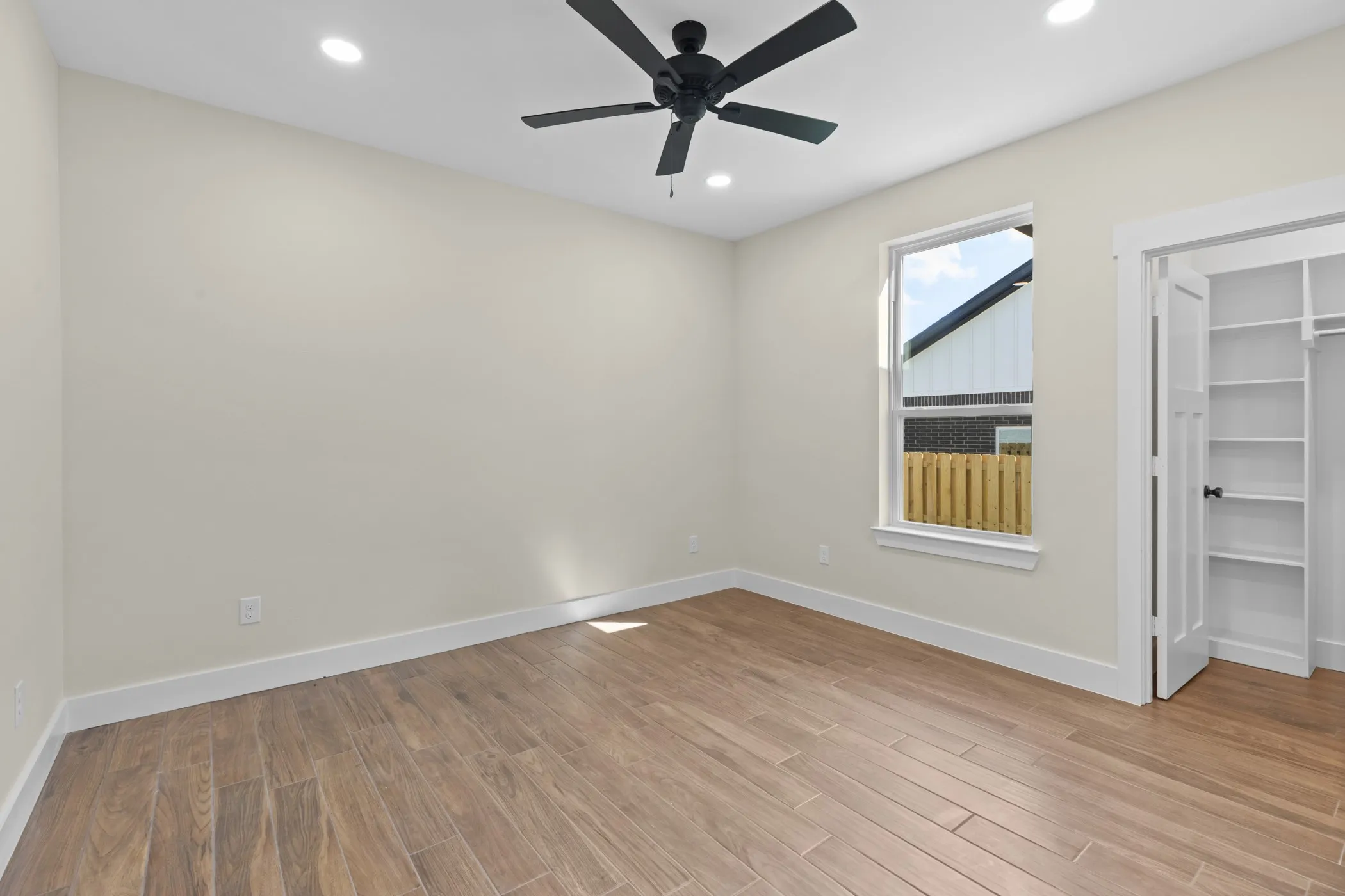 Wood-finish flooring, recessed lighting, and a contemporary ceiling fan