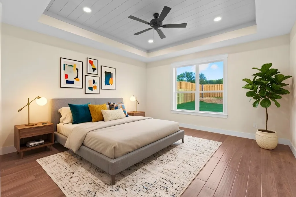 Tray ceiling with recessed lighting and ceiling fan, wood-finish flooring, and a large window