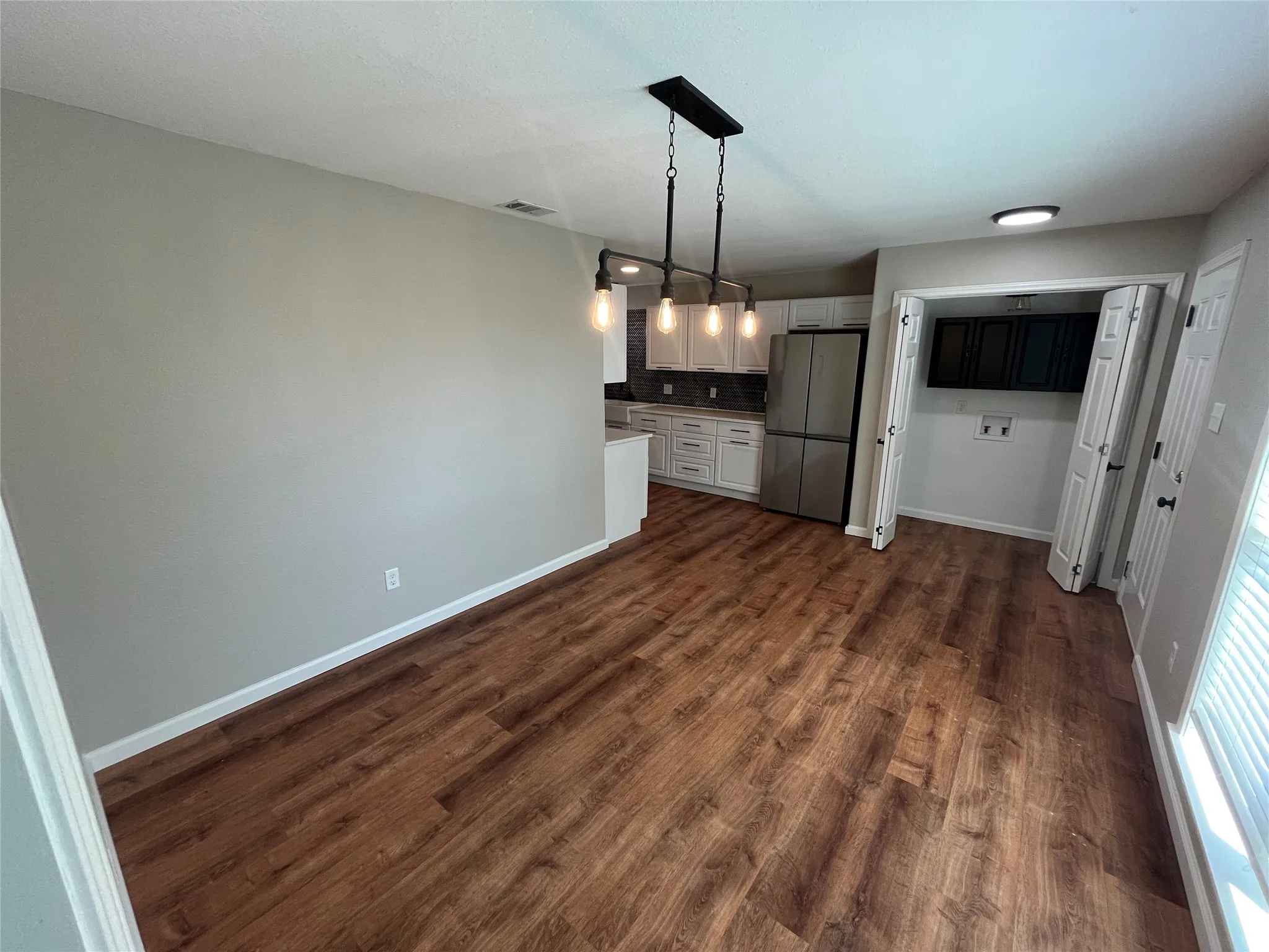 Wood-finish flooring throughout, with a contemporary linear pendant light fixture