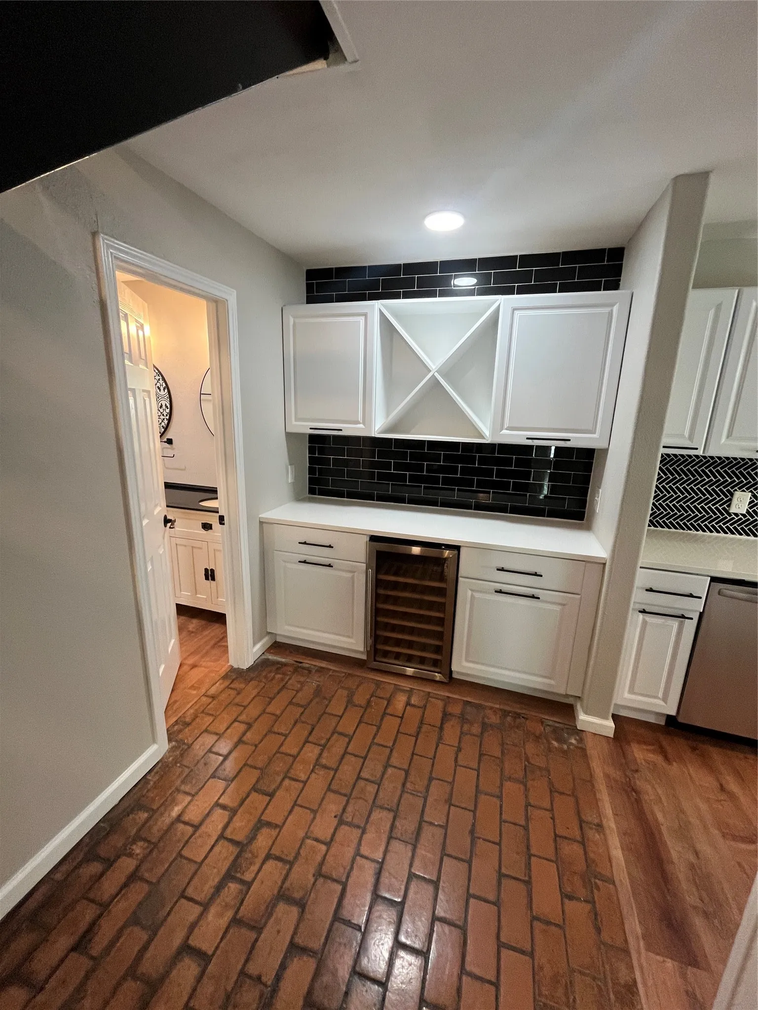 Brick-patterned flooring with built-in cabinetry and an integrated beverage cooler