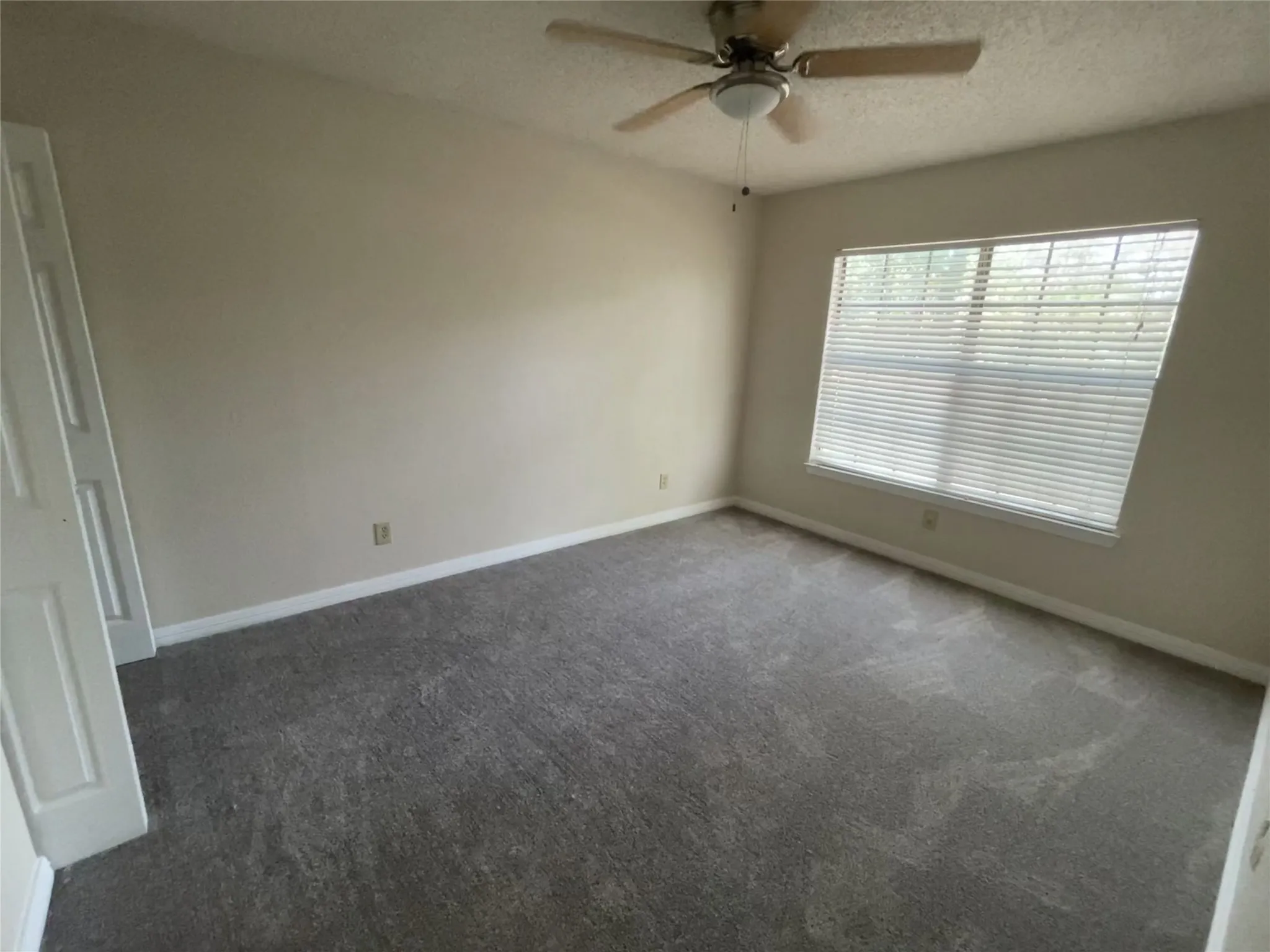 Recessed window with blinds, ceiling fan with integrated lighting, and neutral wall paint