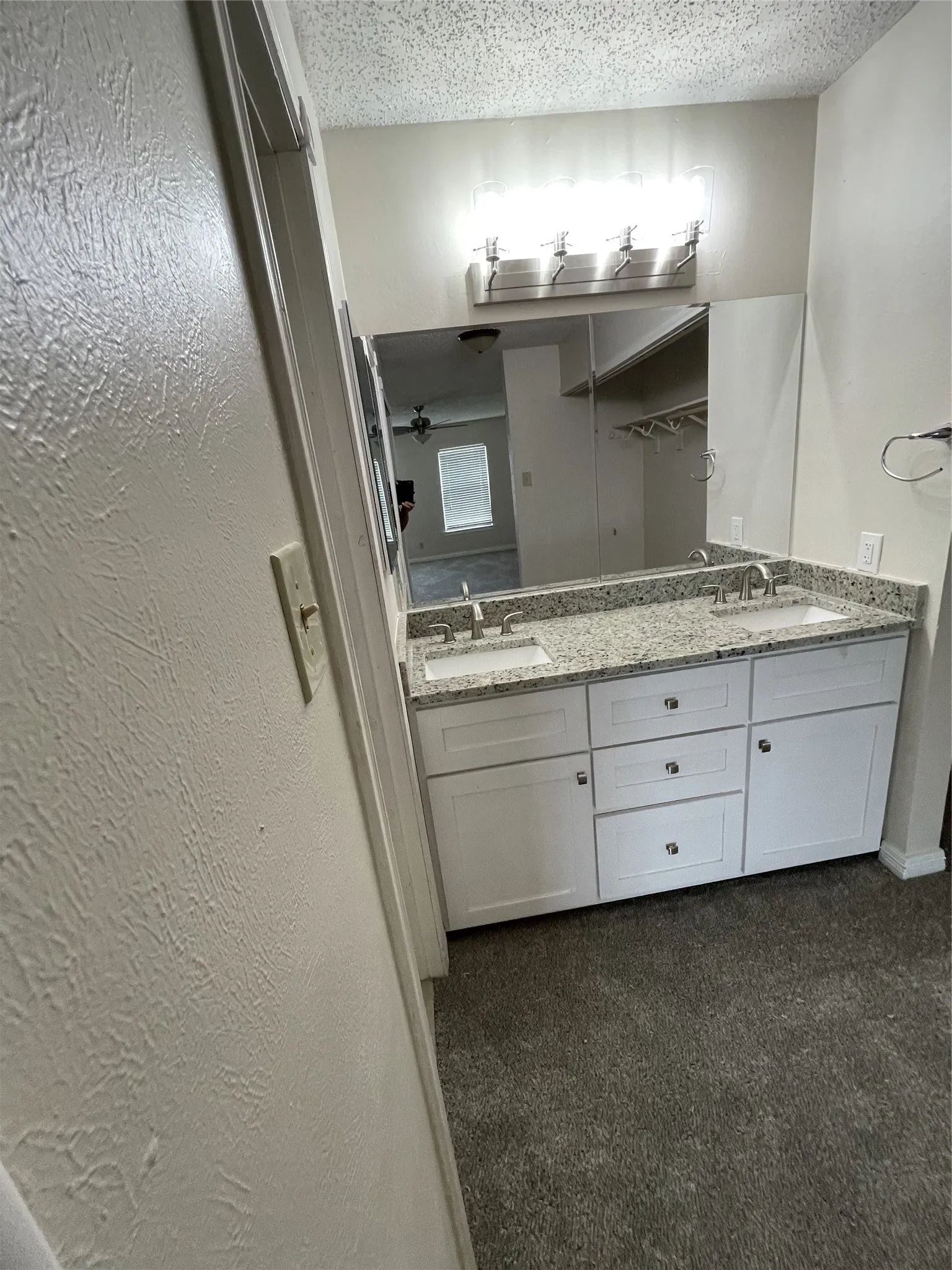 Dual vanity with white cabinetry and granite-style countertop