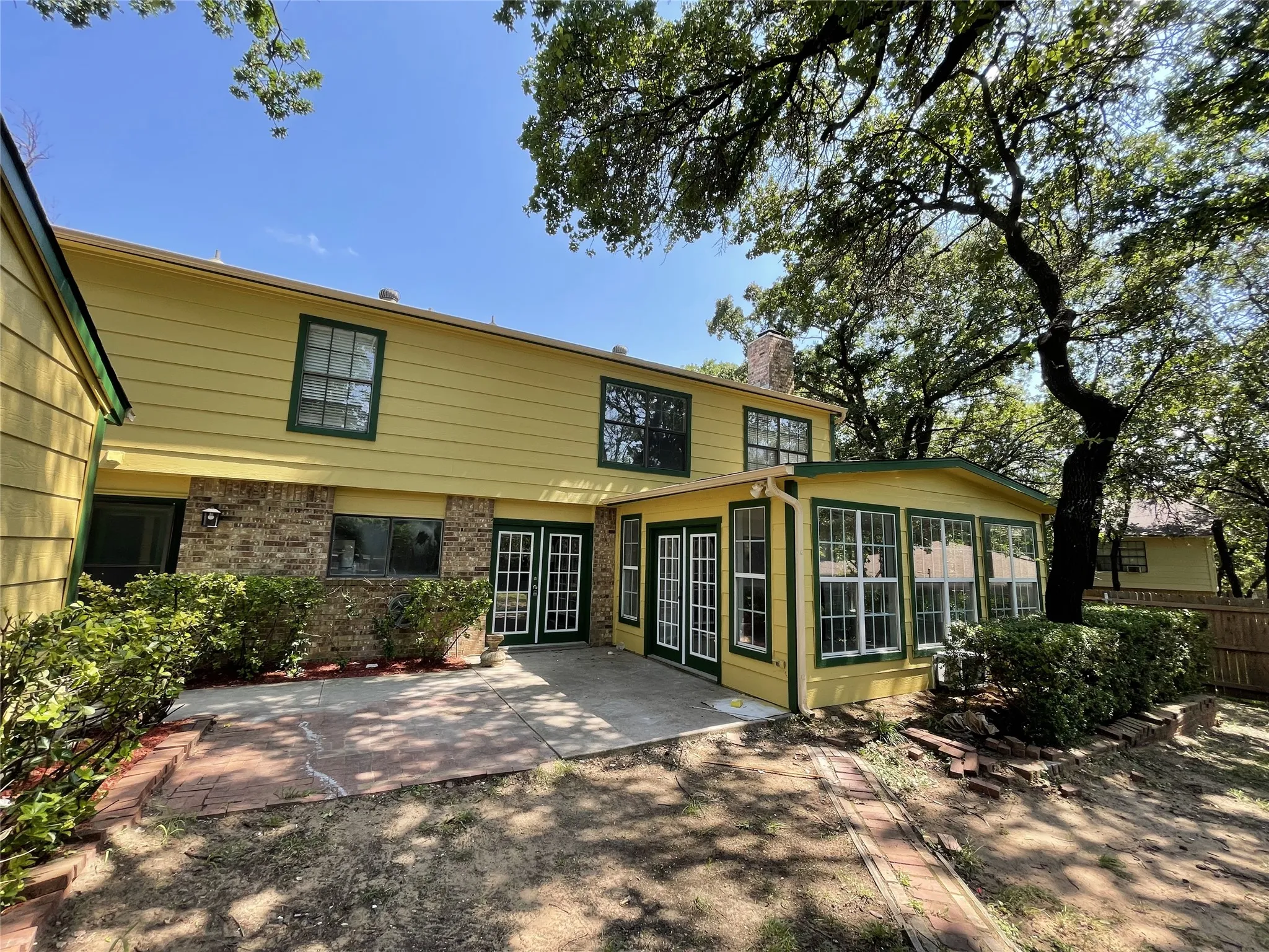 Two-story residence featuring a combination of yellow siding and brick veneer