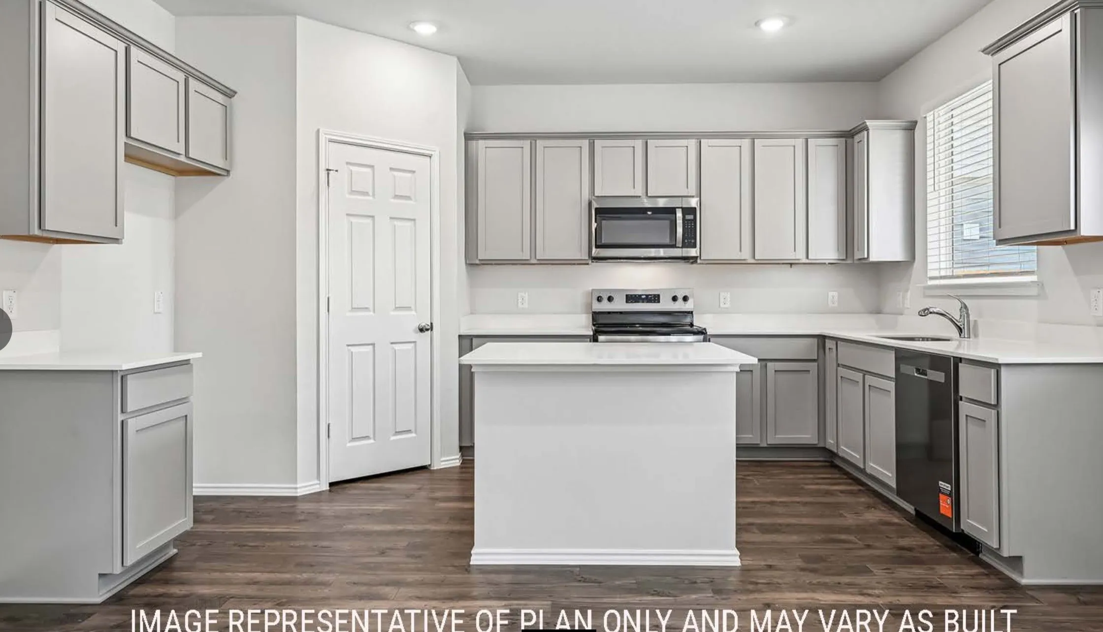 Kitchen featuring an island, light-toned cabinetry, light-toned countertops, stainless steel appliances, and wood-finish flooring