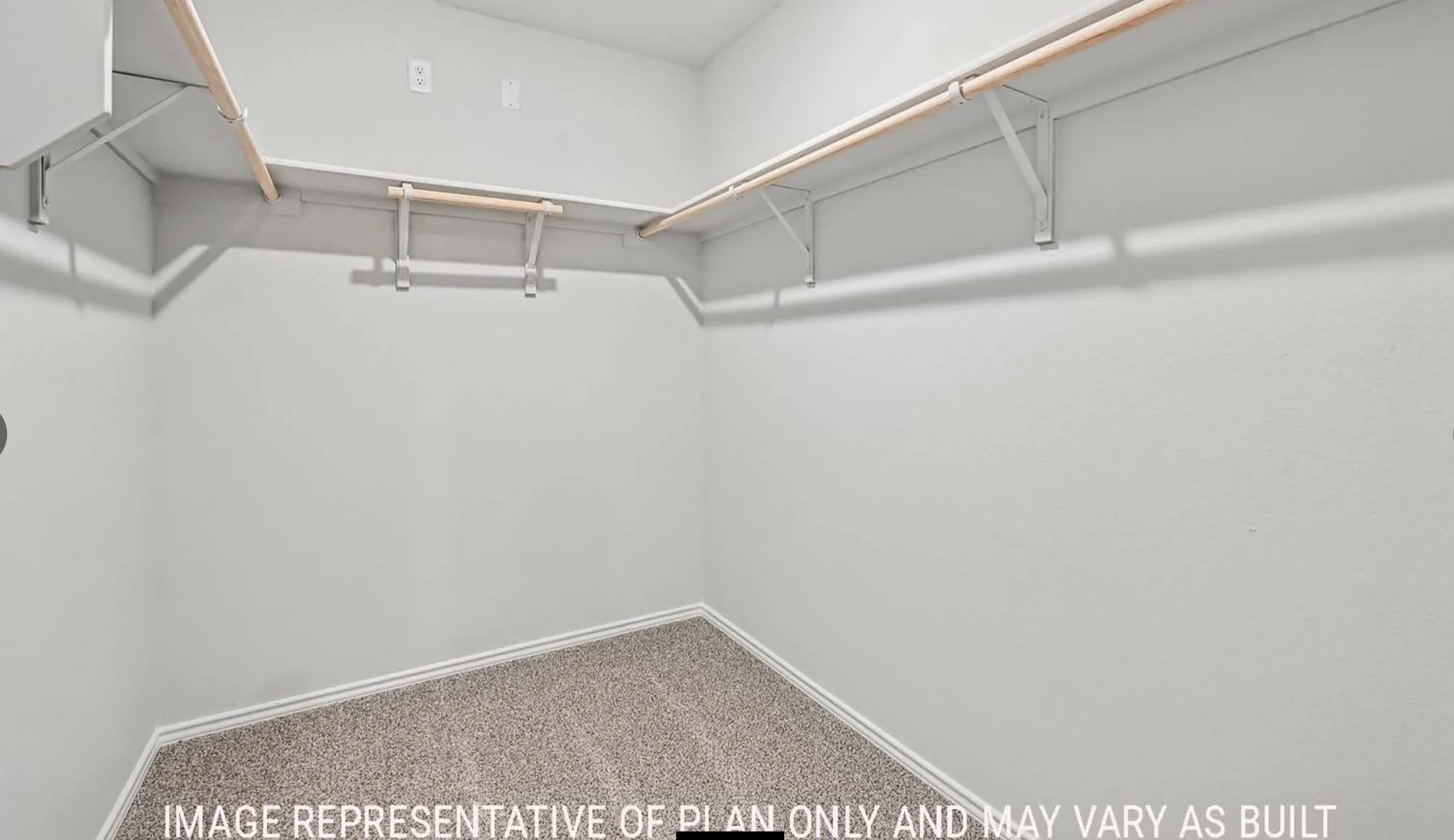 Spacious walk-in closet featuring built-in shelving, hanging rods, and carpet flooring
