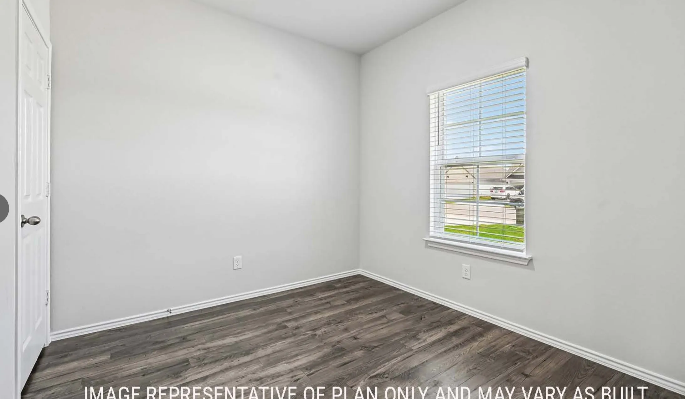 Wood-finish flooring, white walls, and a window with blinds