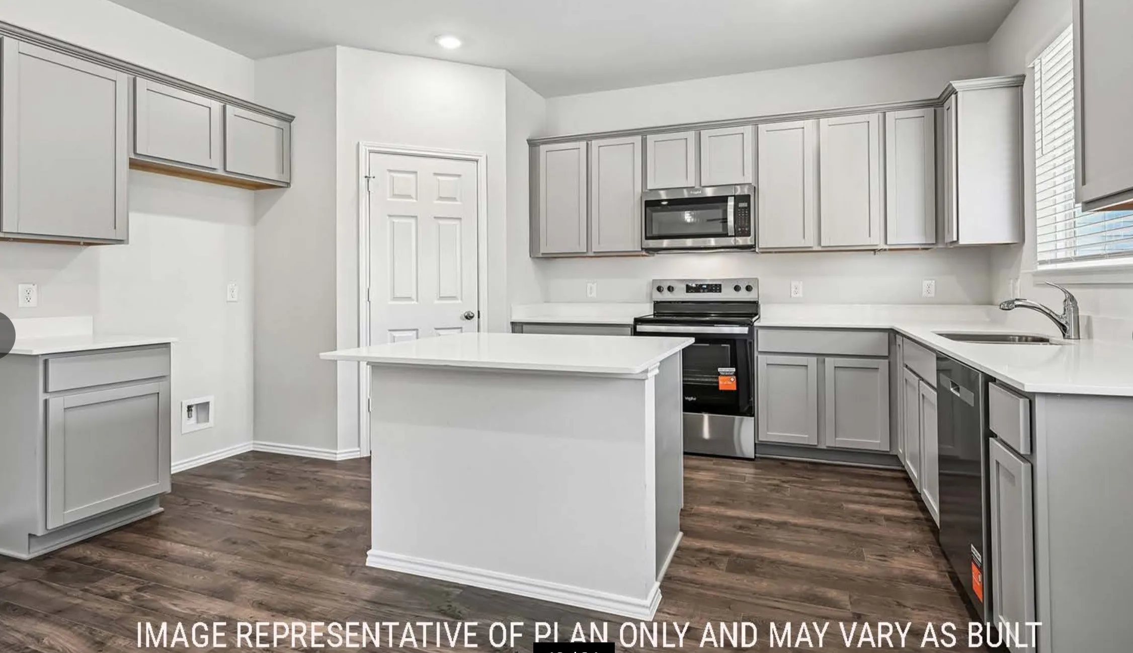 Kitchen featuring an island, light gray cabinetry, white countertops, wood-finish flooring, and stainless steel appliances