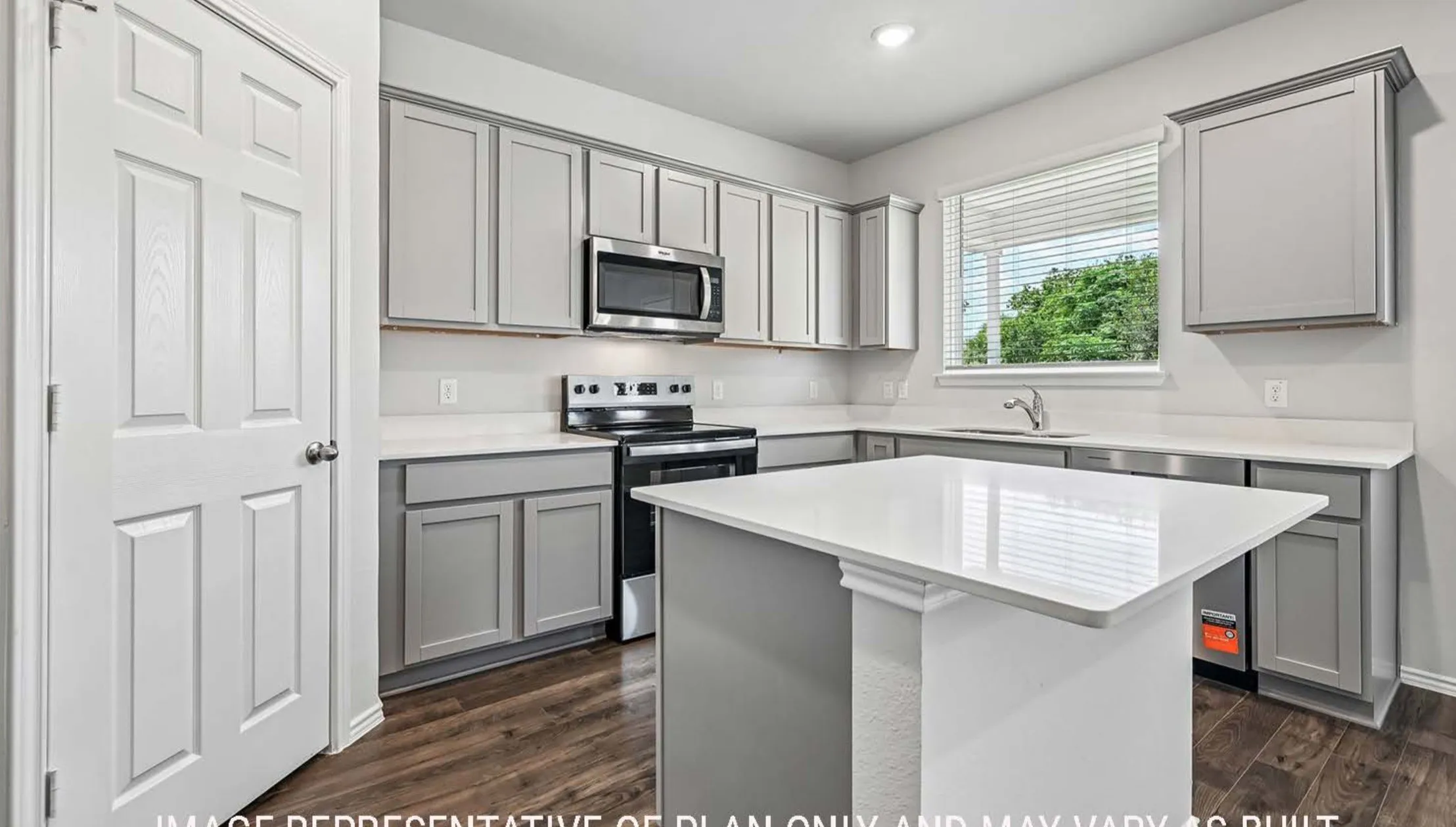 Kitchen featuring light gray cabinetry, white countertops, stainless steel appliances, wood-finish flooring, and a central island