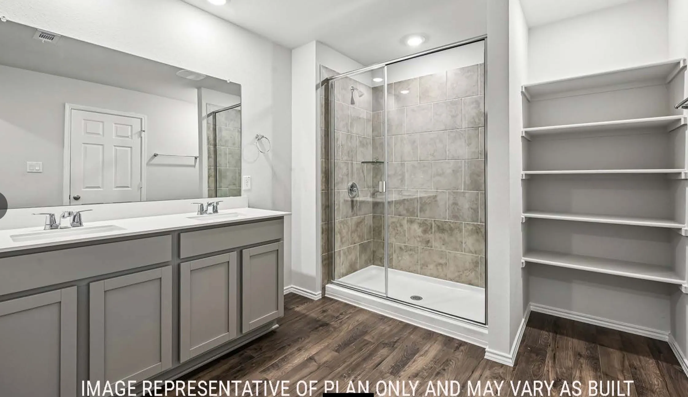 Dual vanity with undermount sinks, wood-finish flooring, glass-enclosed shower with tile surround, built-in shelving, and recessed lighting