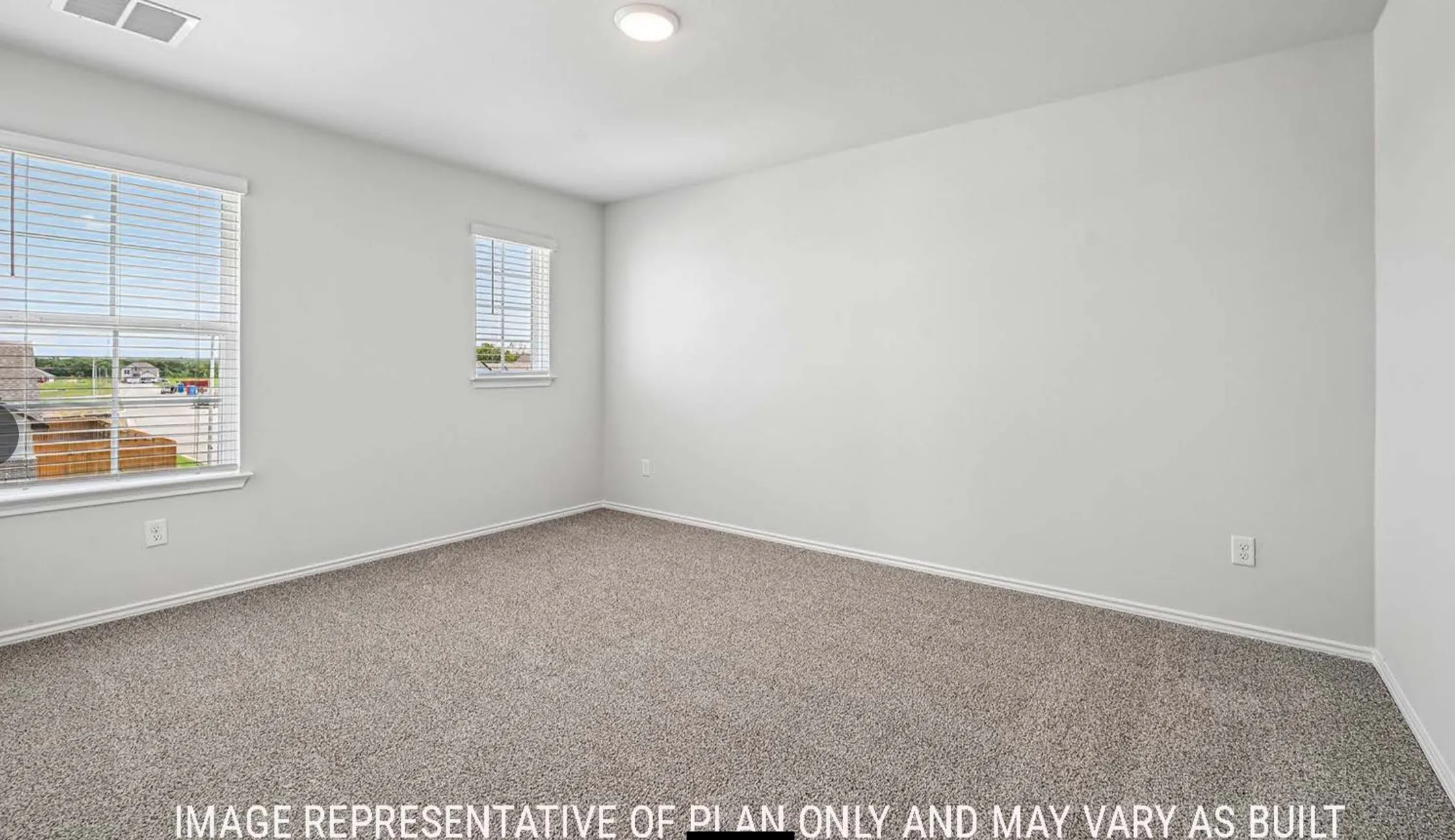 Carpeted flooring, two windows with blinds, recessed lighting, and light-toned walls