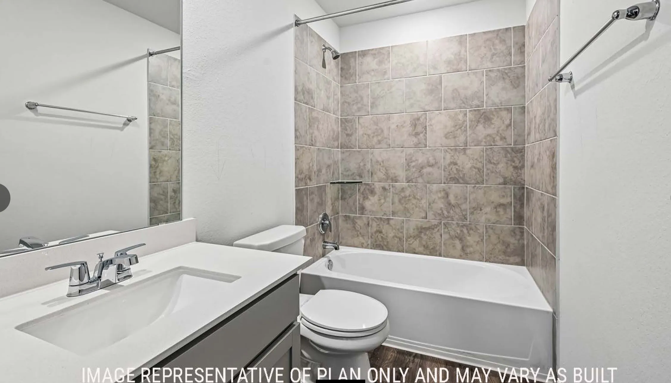 Vanity with integrated sink and chrome faucet, large mirror, and tiled shower/tub combination