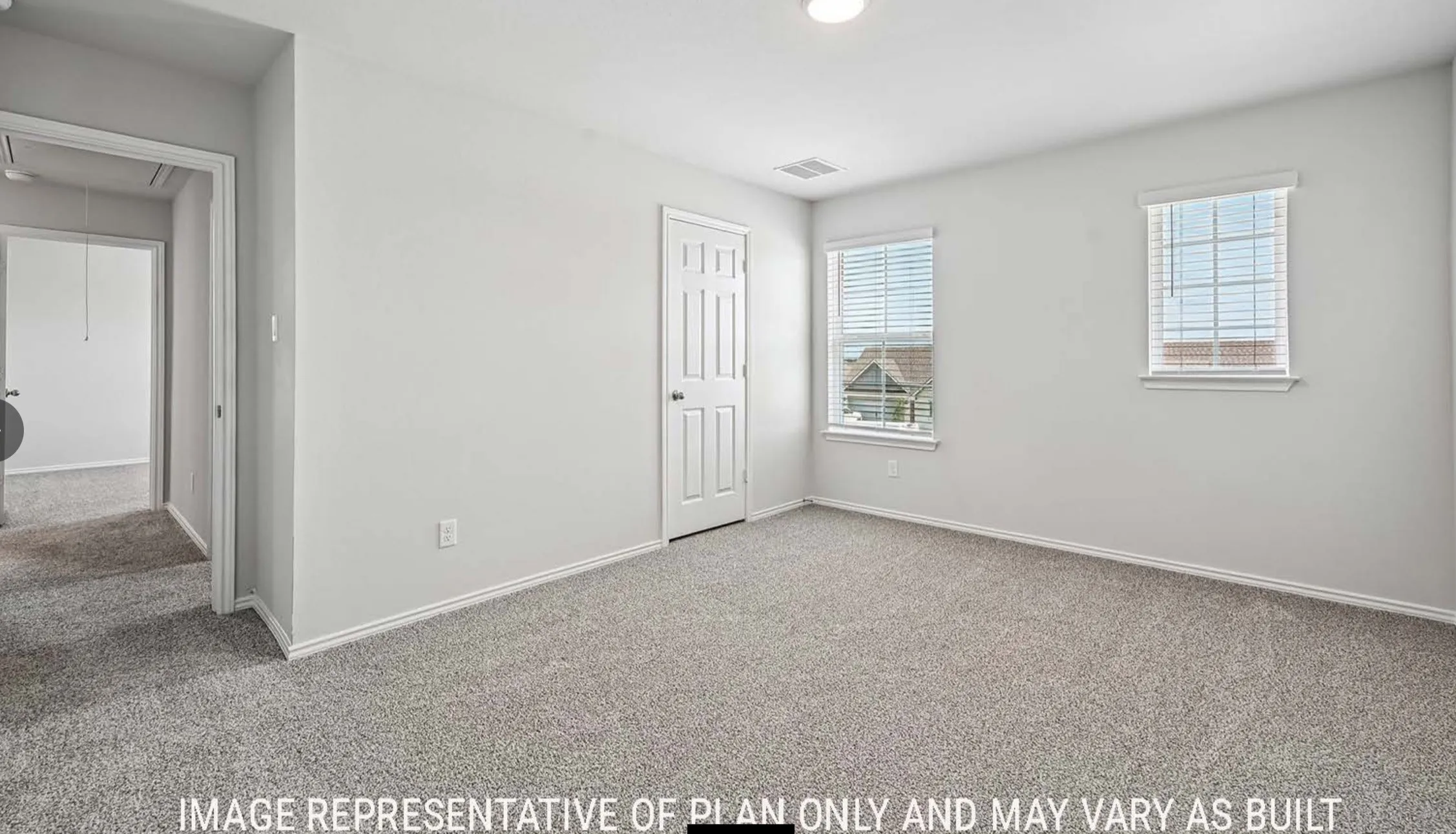 Light gray carpeting, white painted walls, two windows with blinds, a white paneled door, and a flush mount ceiling light