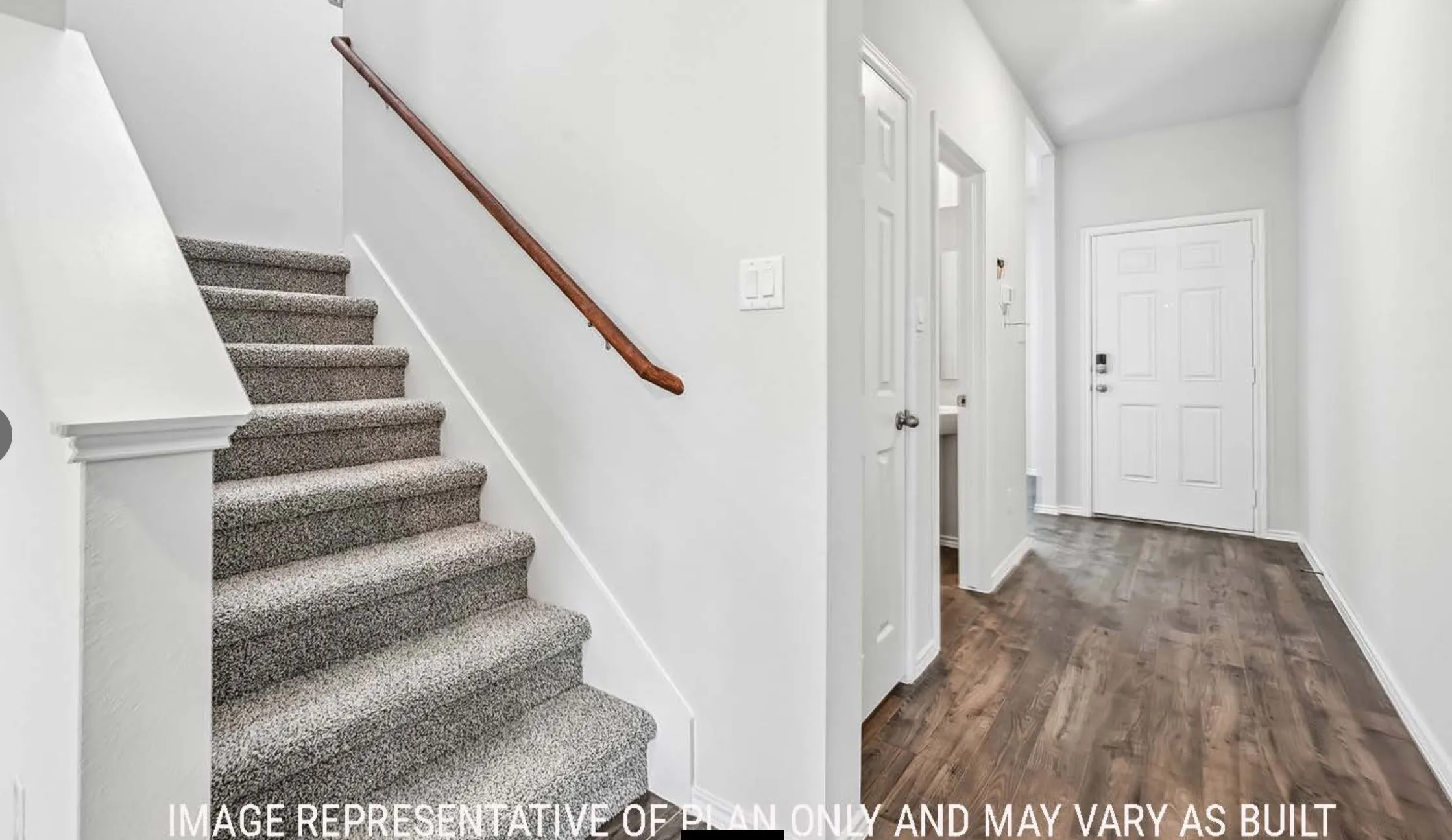 Carpeted staircase with wood handrail, wood-finish flooring, and white paneled doors