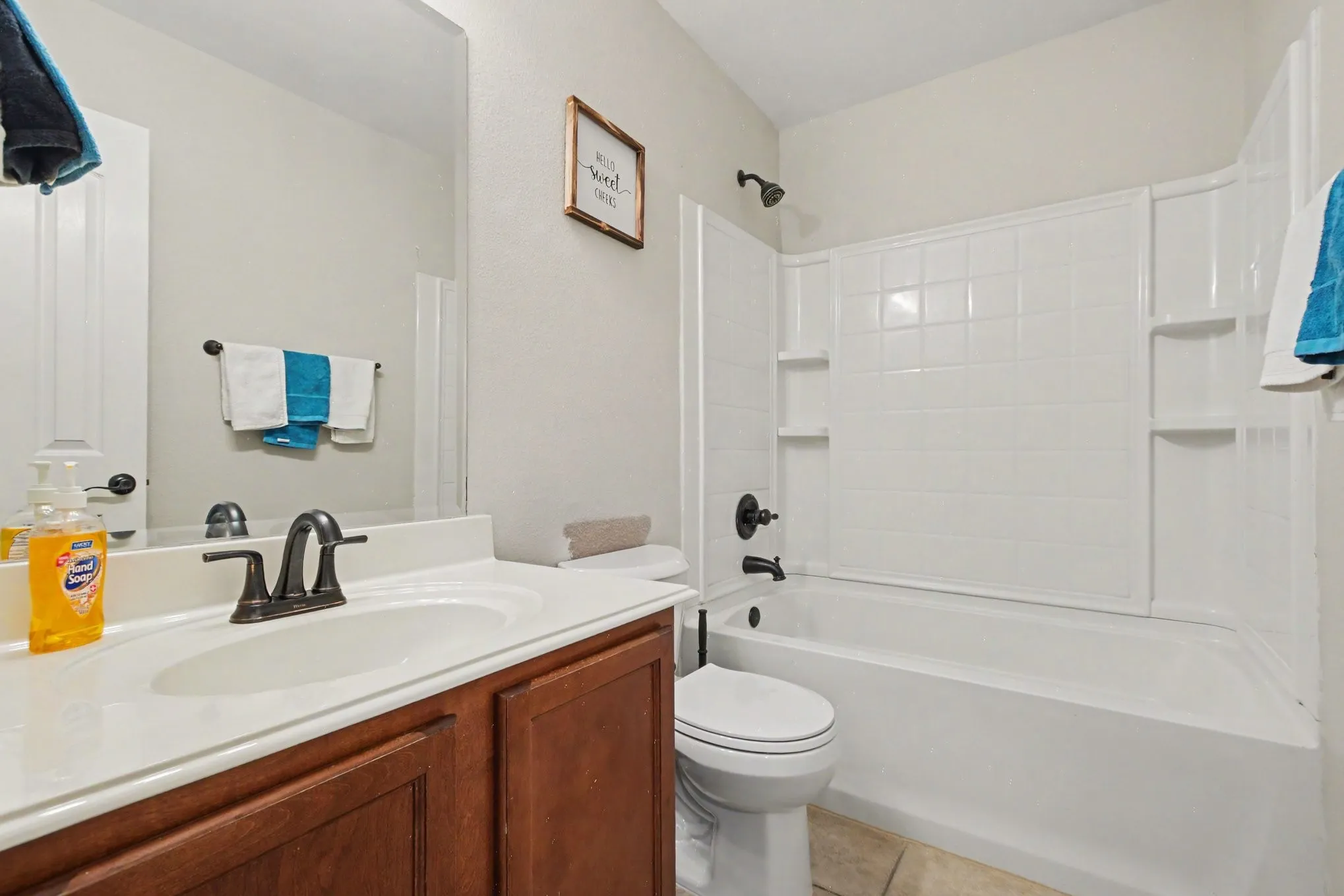 Bathroom 2 featuring a vanity with dark wood-finish cabinetry, a white countertop with an integrated sink, and an oil-rubbed bronze faucet