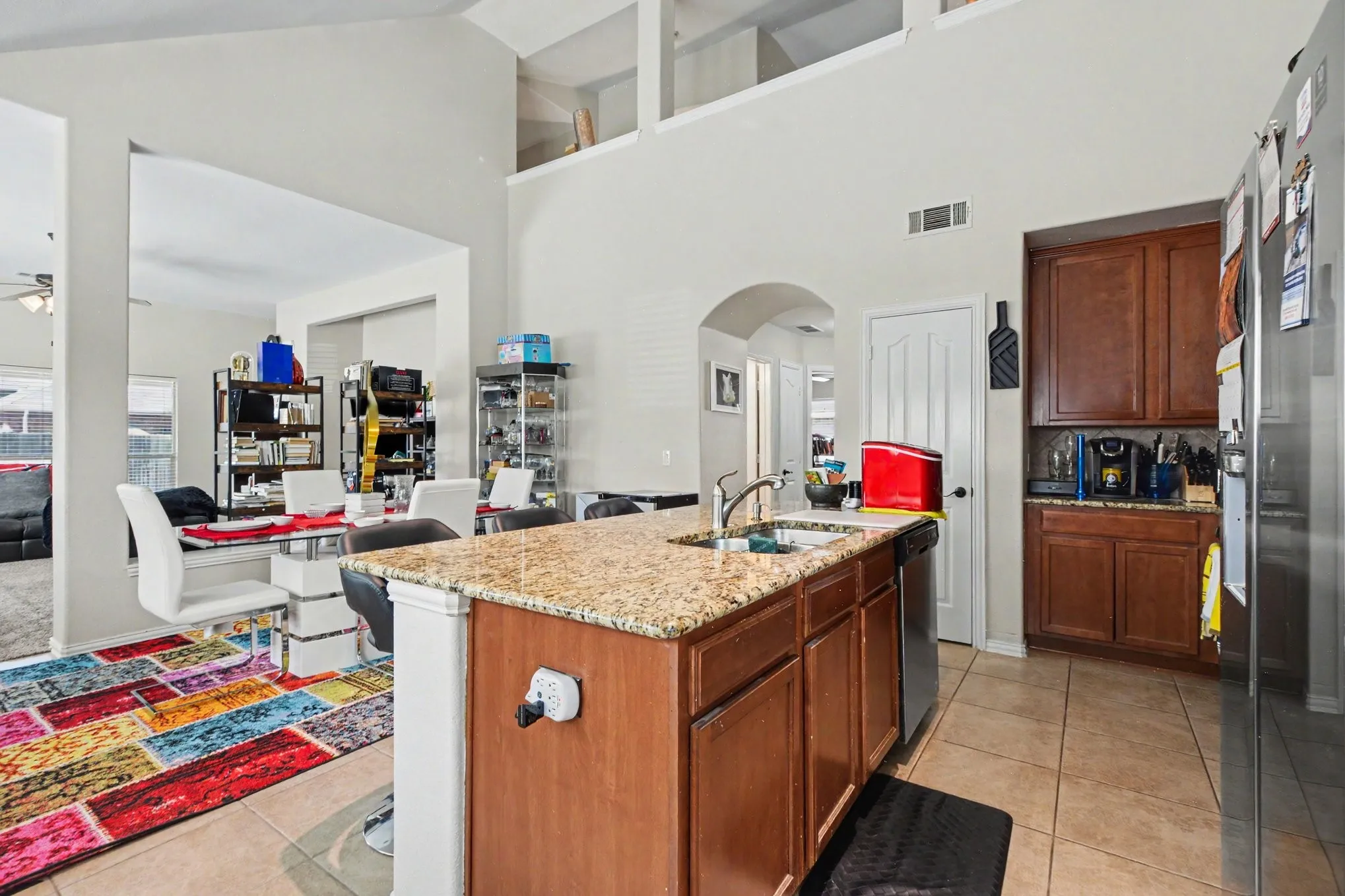 Kitchen island with a granite-style countertop and an undermount sink