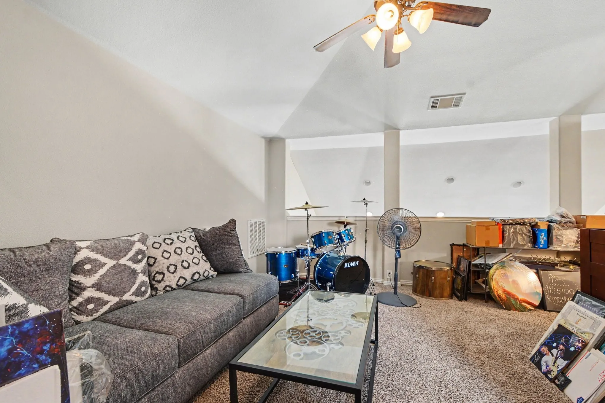 Carpeted flooring with a ceiling fan and overhead lighting