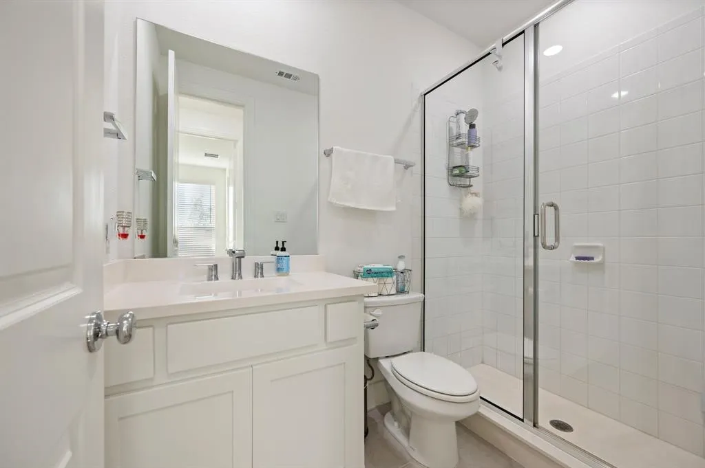 Vanity with a polished chrome faucet, rectangular undermount sink, and light-toned countertop