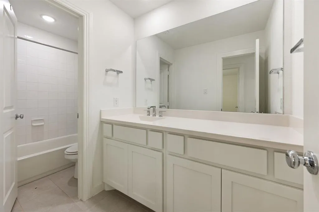 White bathroom vanity with light countertop, undermount sink, and chrome fixtures