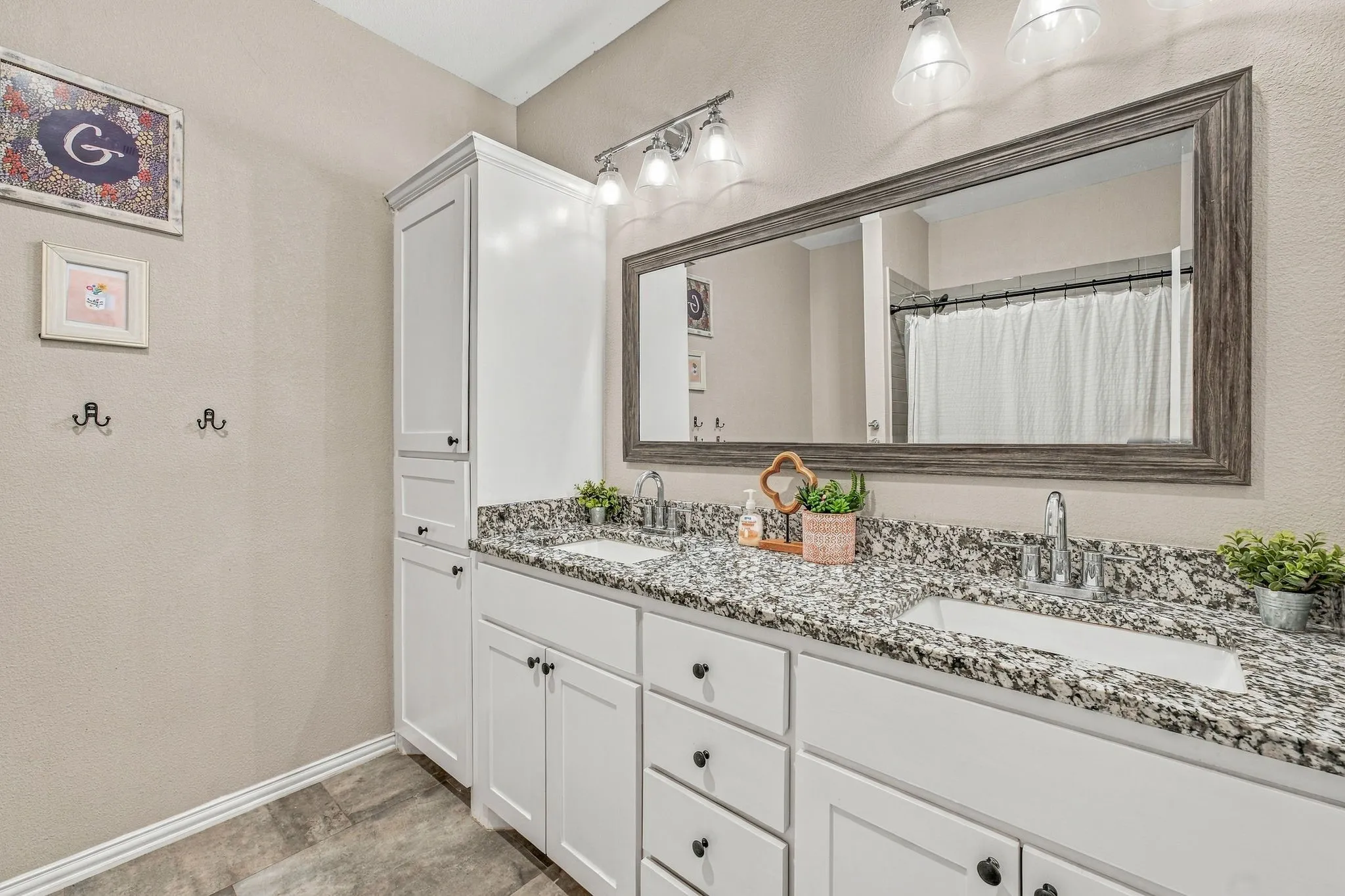 Dual vanity with drop-in sinks, speckled countertops, and individual chrome faucets