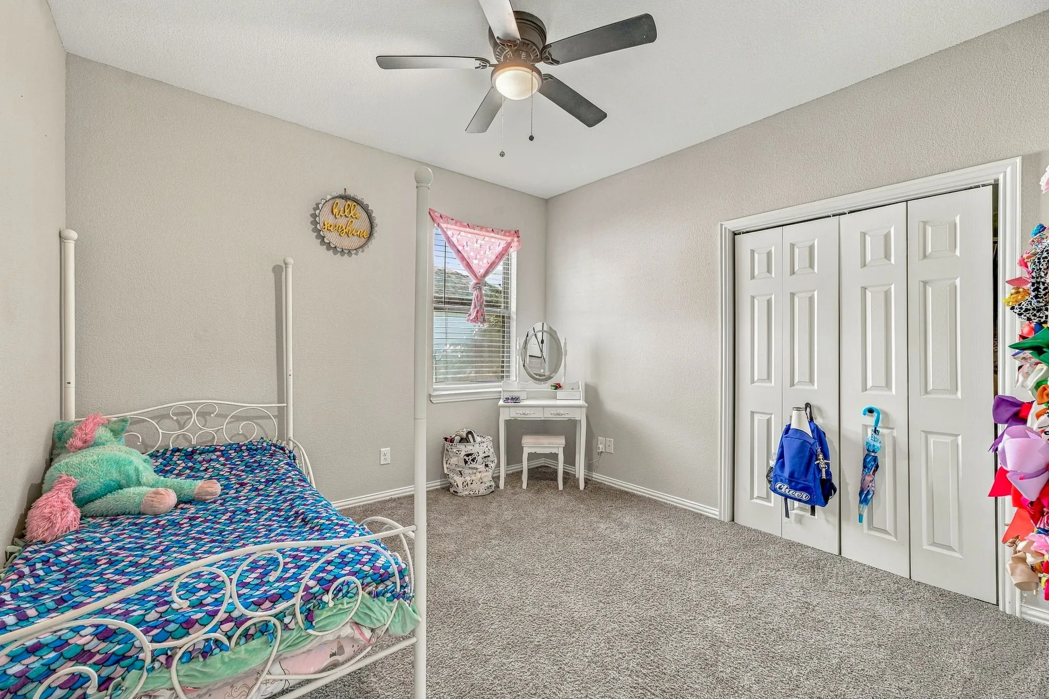 Carpeted room featuring a ceiling fan with integrated lighting, a window with blinds, and white bi-fold closet doors