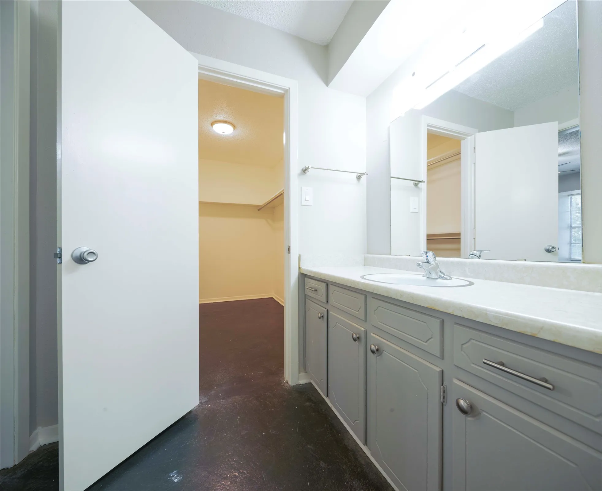 Vanity with an integrated sink, polished chrome faucet, and gray cabinetry with silver hardware