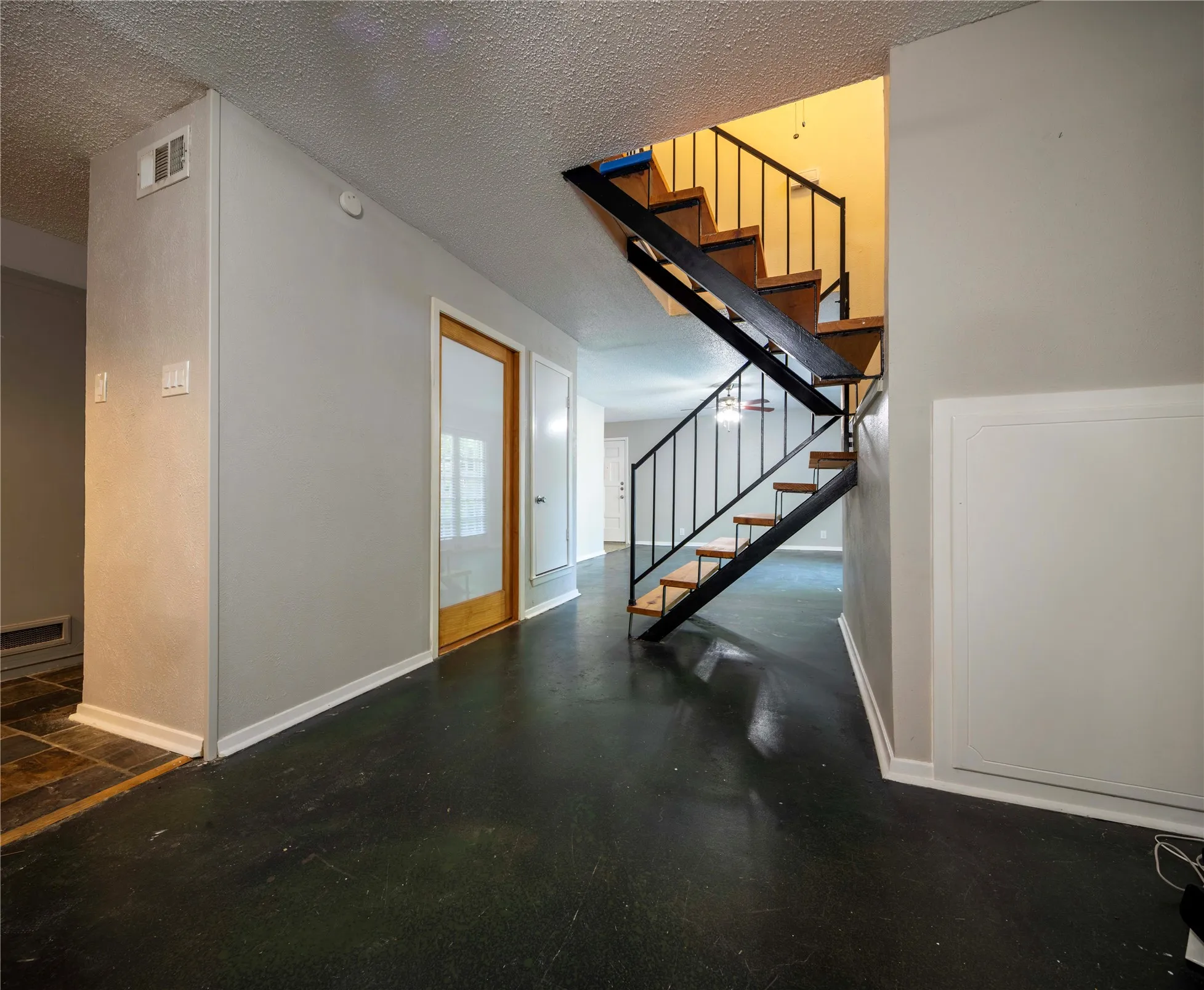 Open-tread staircase with wood stairs and black metal railing