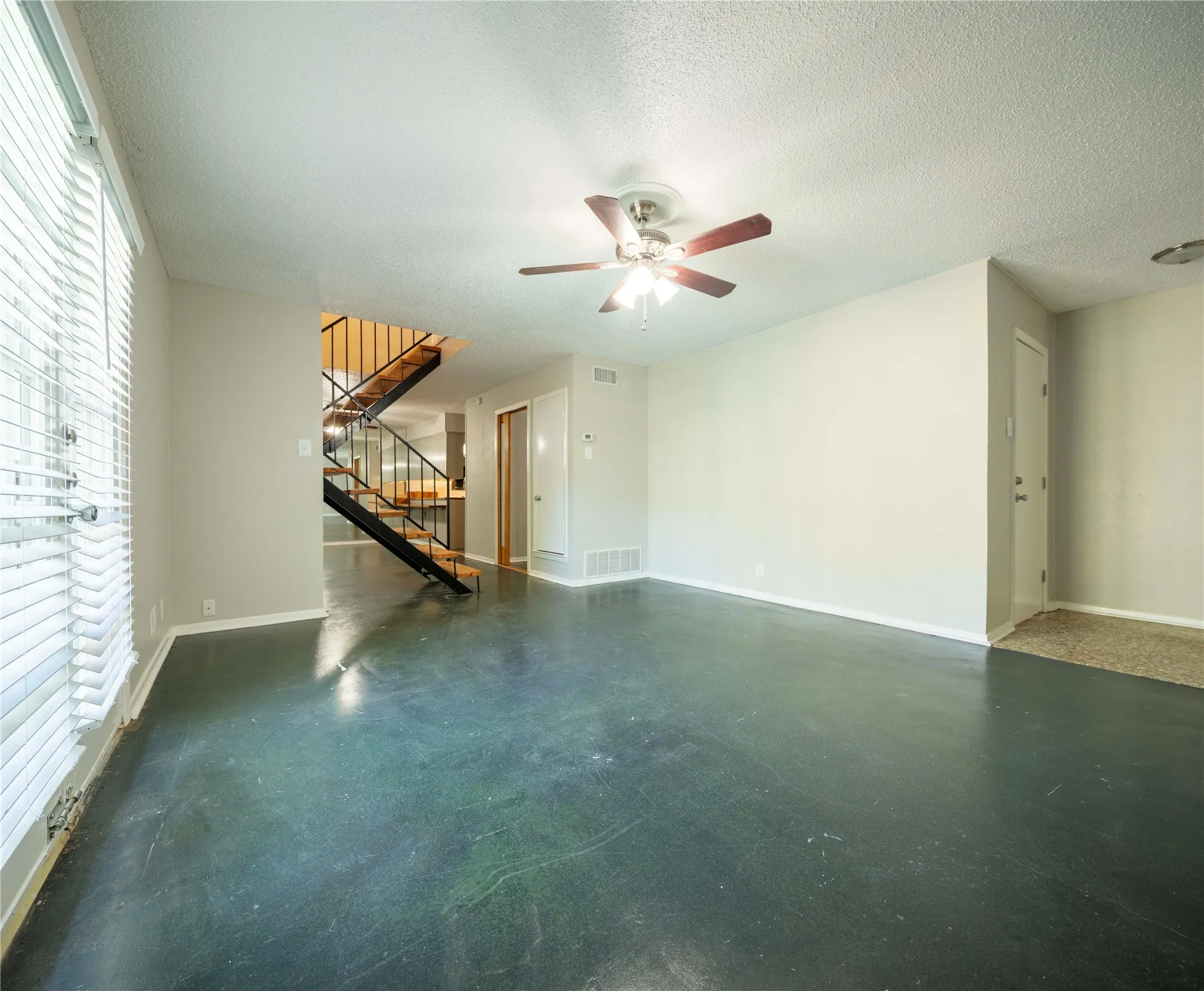 Polished concrete flooring with a ceiling fan light fixture