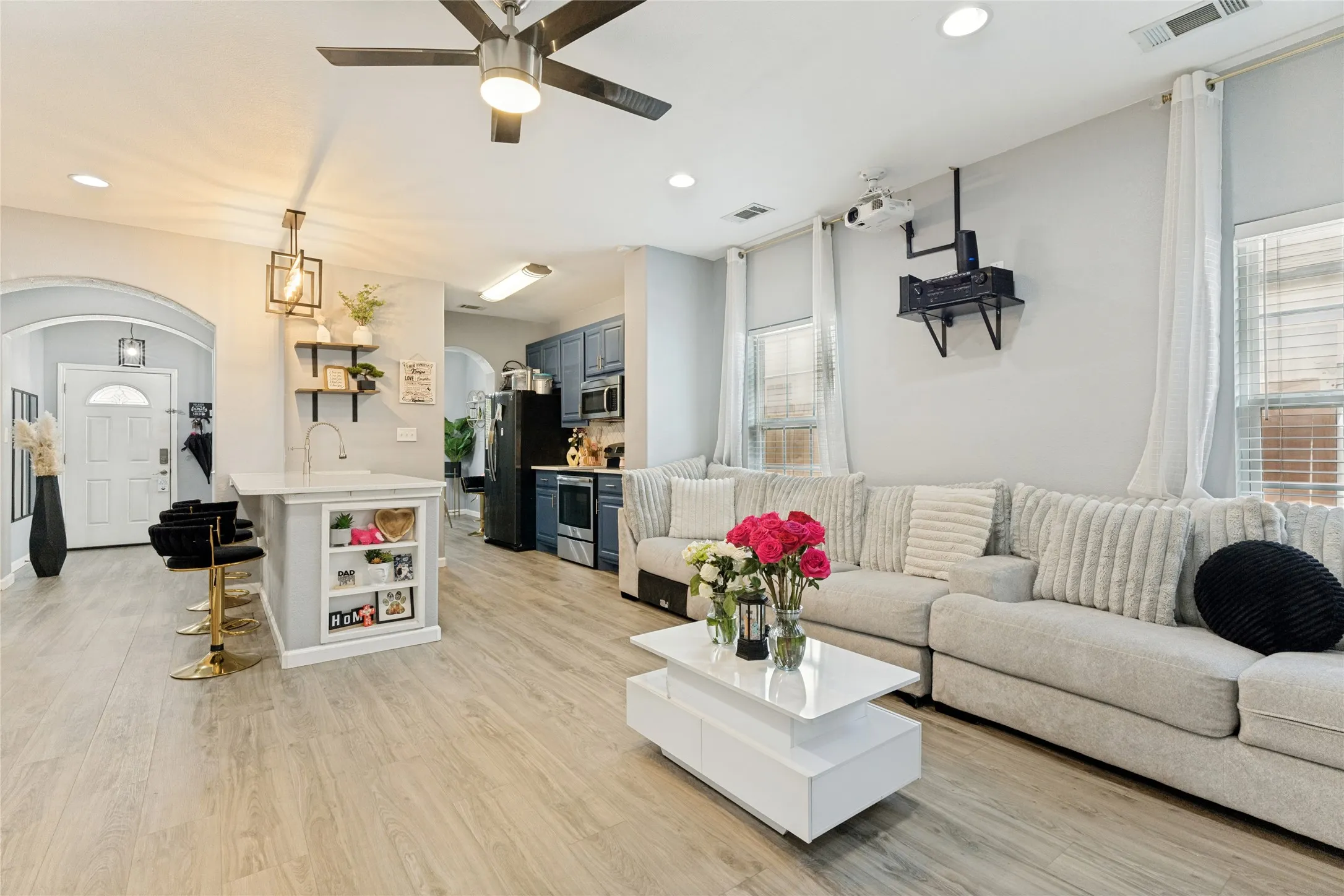 Open-concept living area featuring wood-finish flooring, recessed lighting, and a ceiling fan
