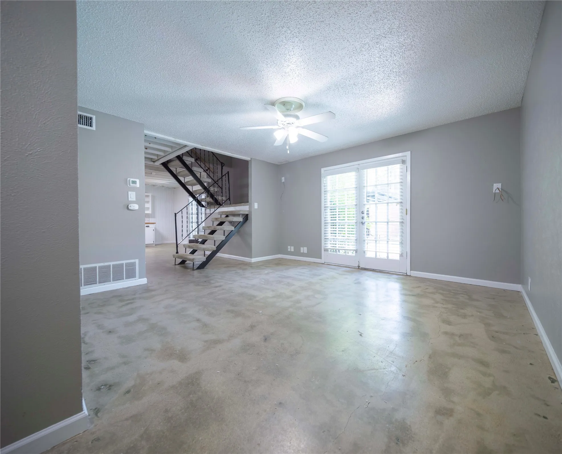 Exposed concrete flooring complemented by light gray wall tones