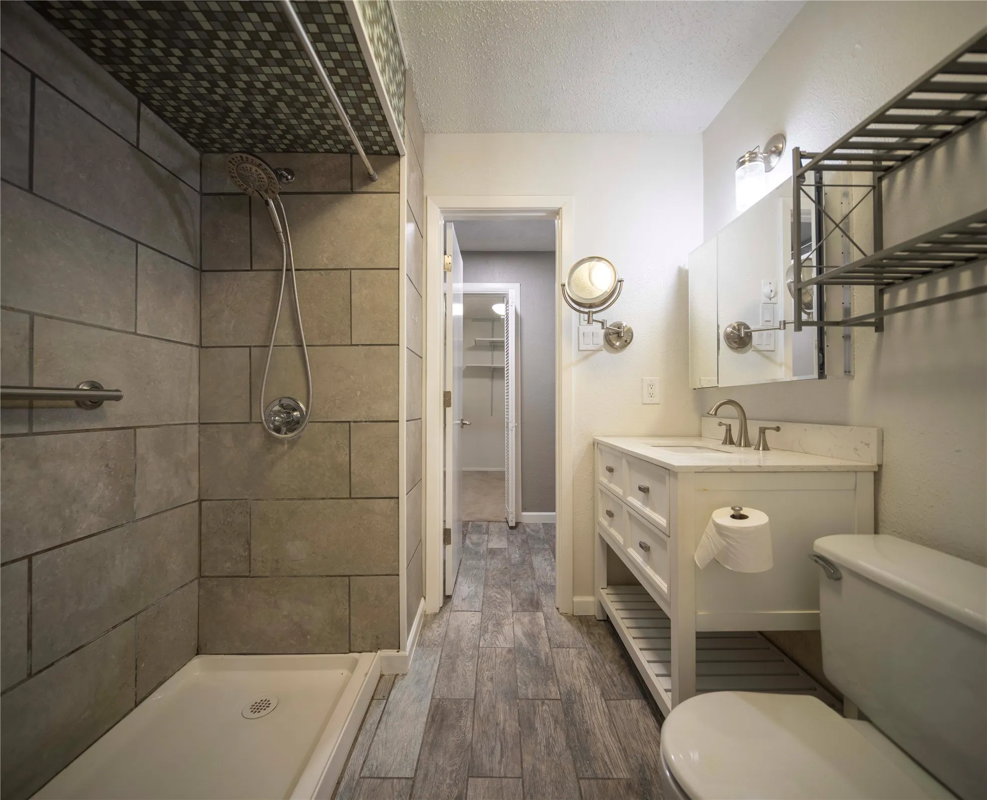 Walk-in shower with large format tile surround and mosaic tile ceiling detail
