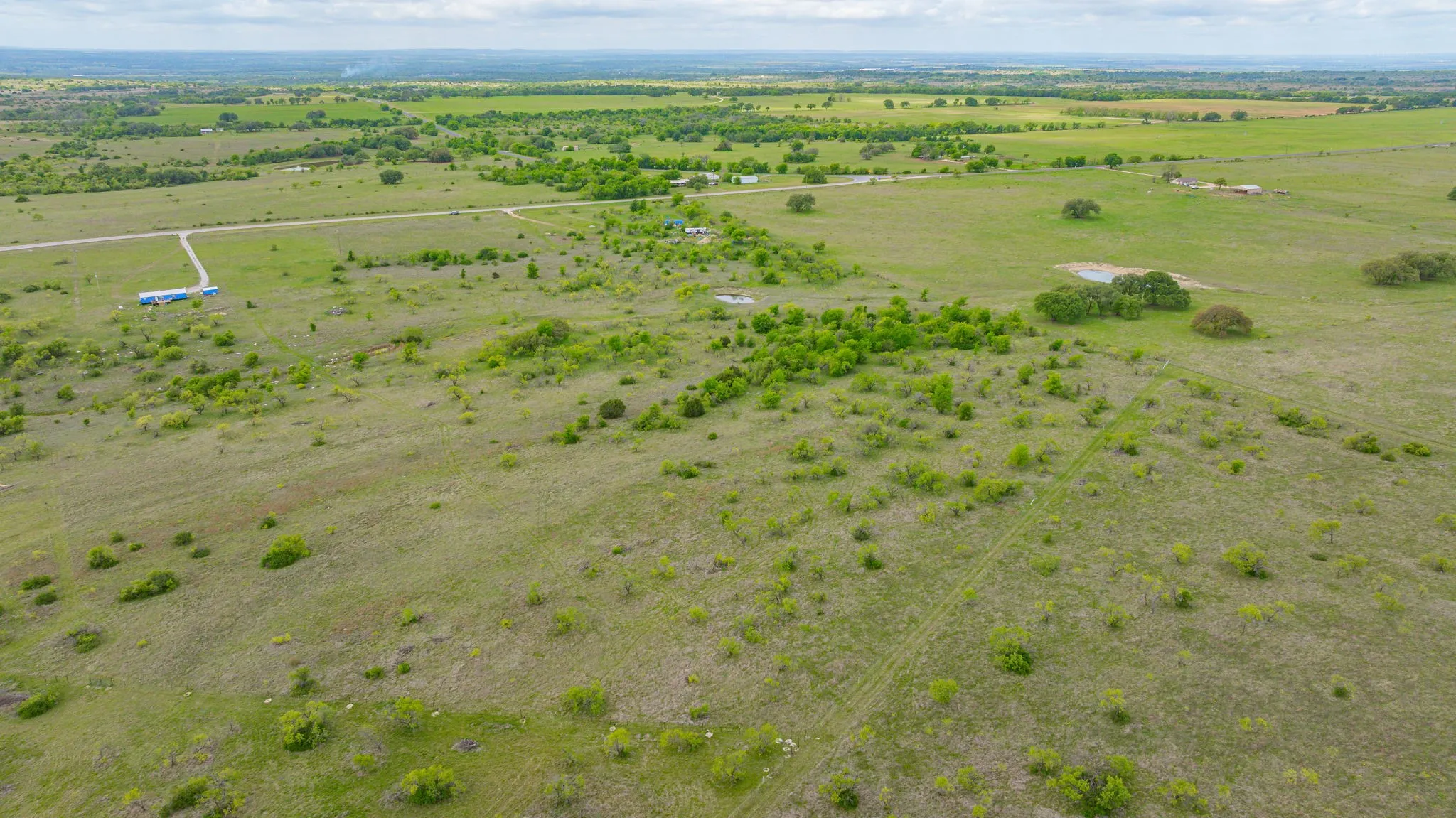 Expansive acreage featuring established vegetation, natural clearings, and a developed access road