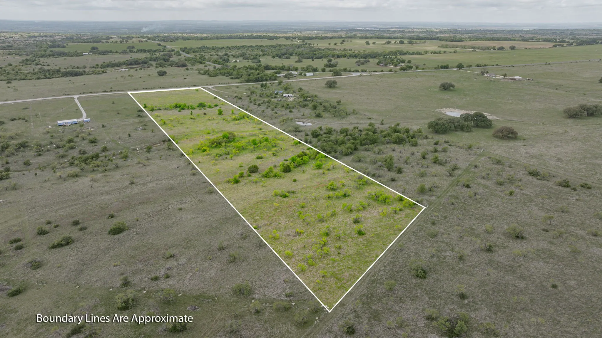 Expansive undeveloped land featuring scattered vegetation and a natural terrain