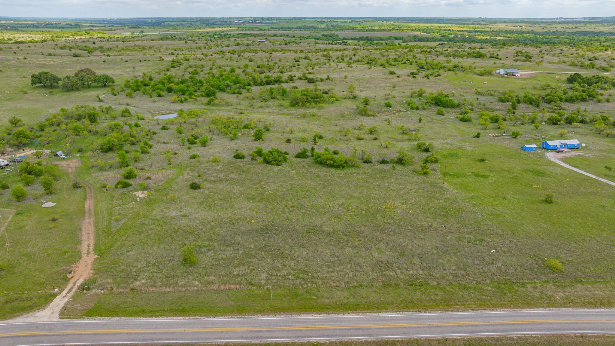 Expansive open land with scattered trees and natural vegetation