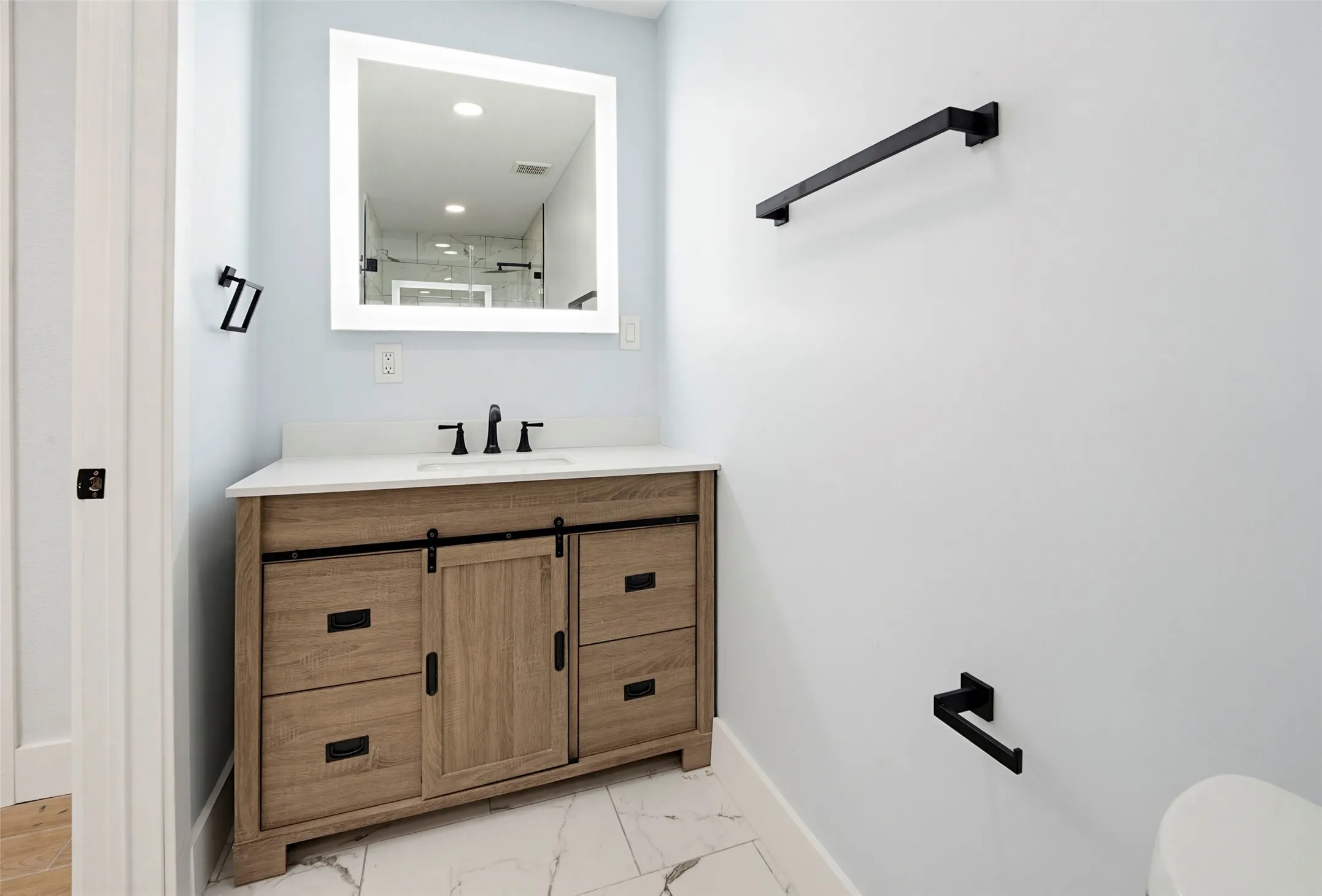 Wood-finish vanity with a white countertop and undermount sink