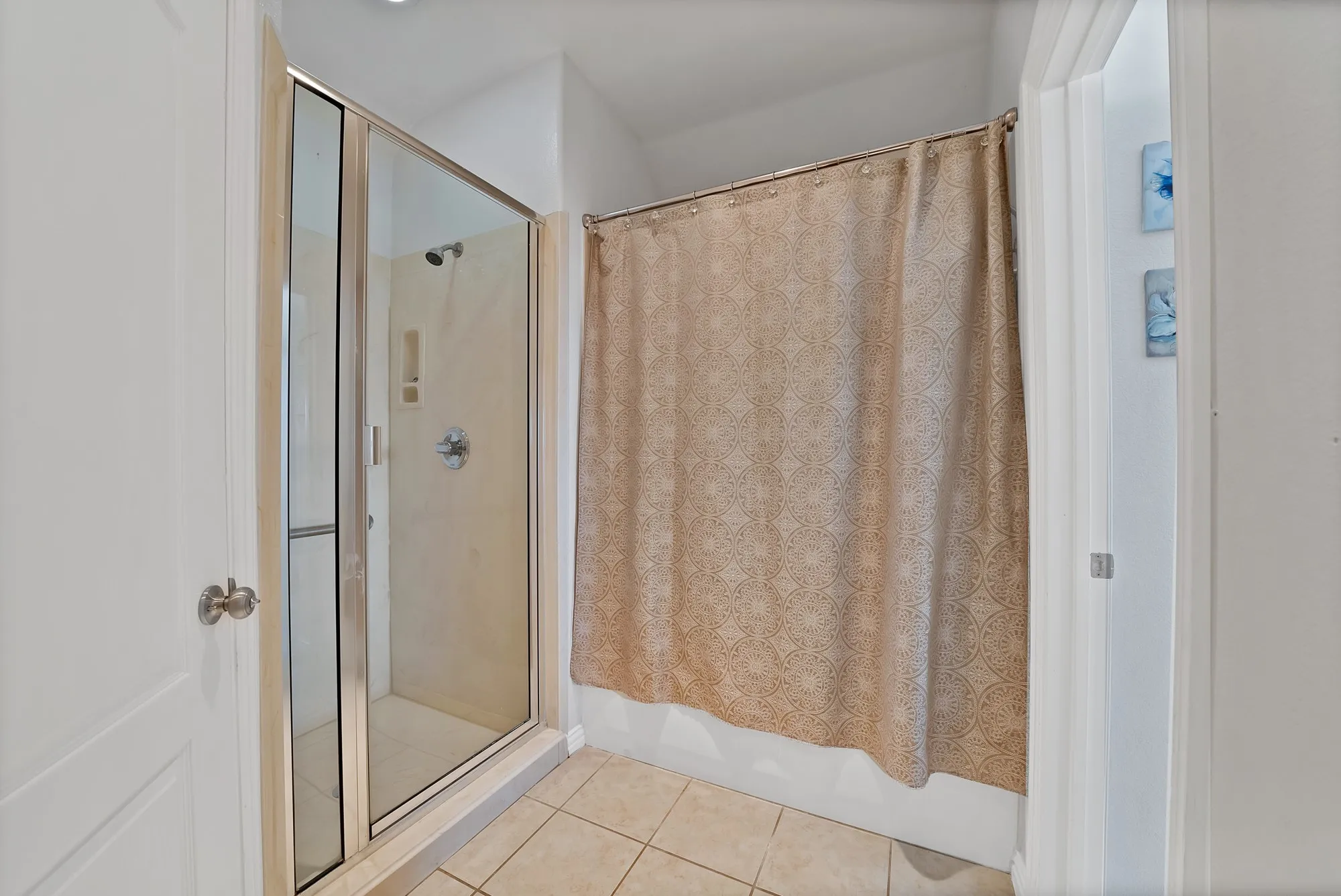Secondary bathroom, shower detail — Walk-in shower with glass door enclosure, tile surround with built-in niche, and separate tub-shower combination. Large-format tile​​‌​​​​‌​​‌‌​‌‌​​​‌‌​‌​‌​‌​​​‌​​ flooring.