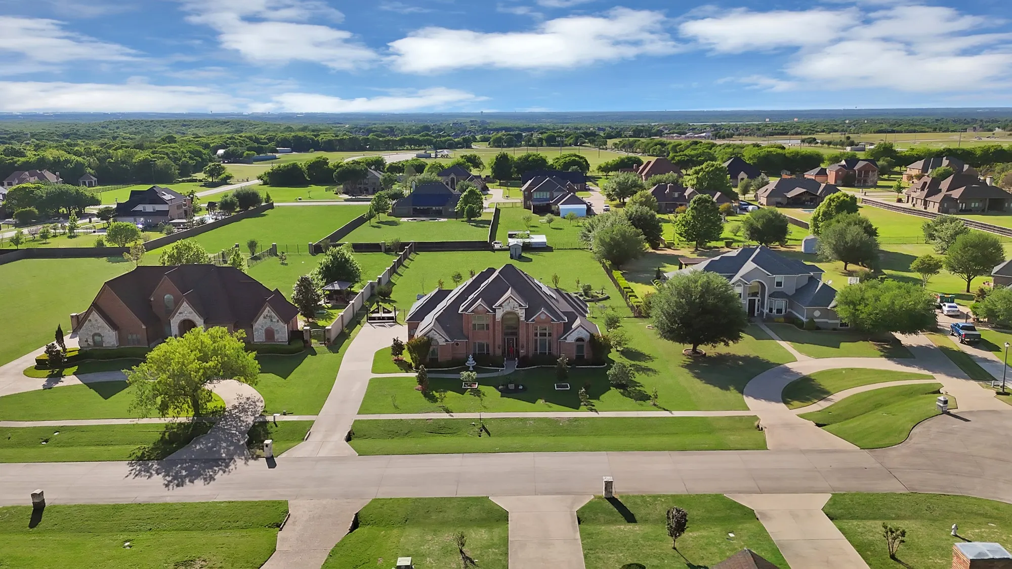 Aerial view — Cul-de-sac lot position with large fenced rear yard, covered back patio structure visible, and open North Texas horizon beyond the neighborhood.