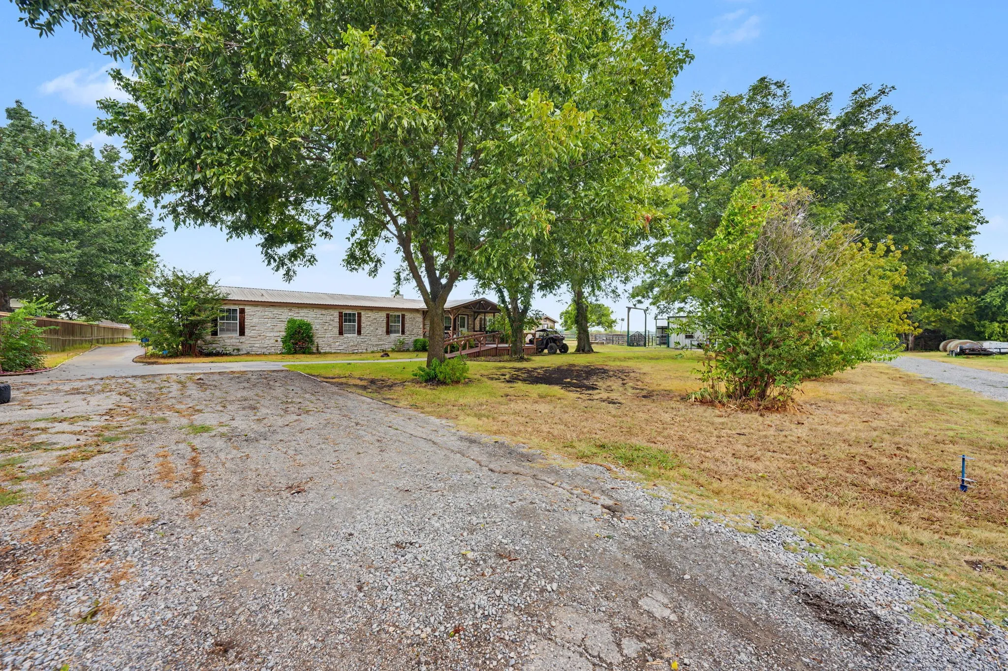 Front exterior featuring a large mature pecan tree and spacious yard.
