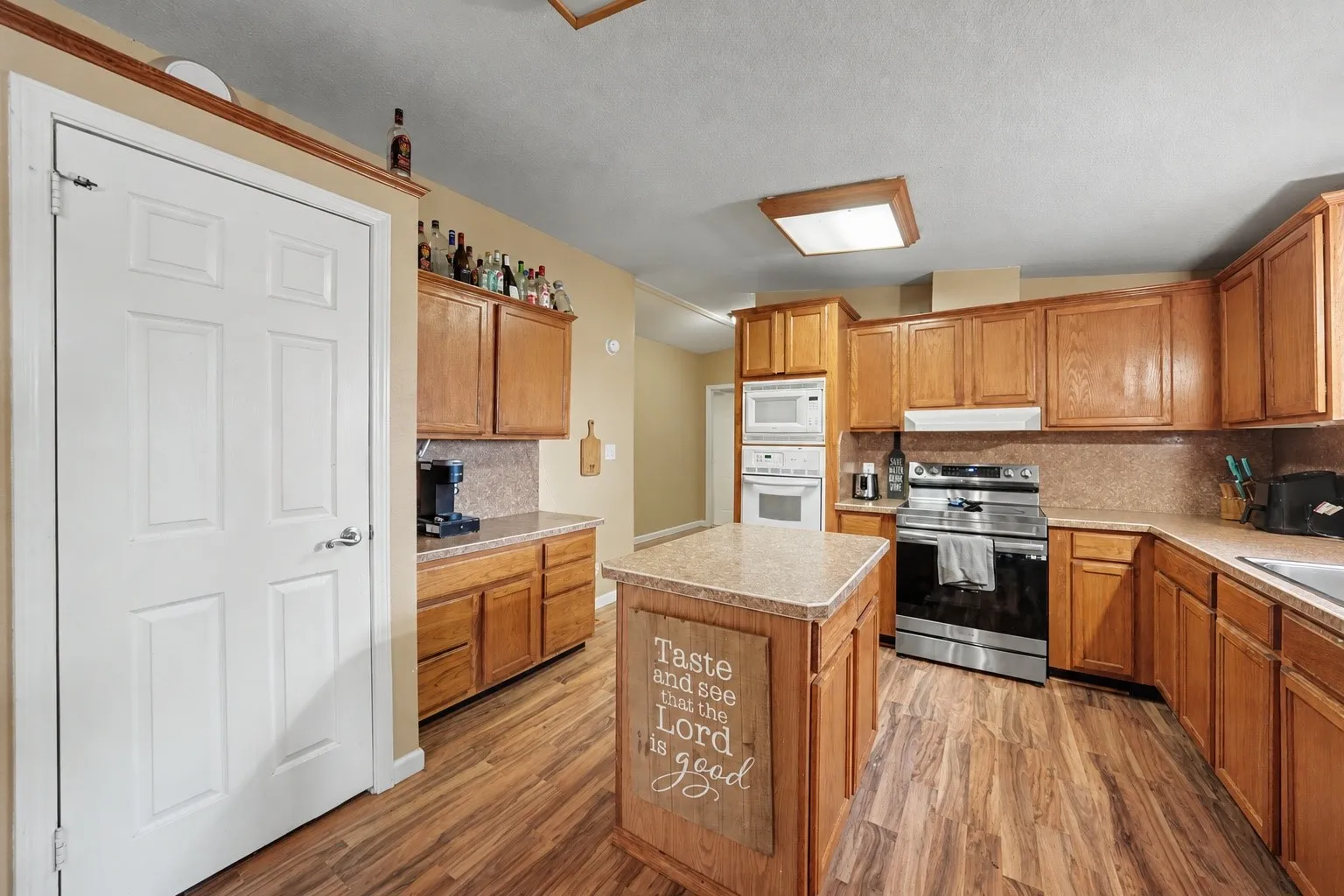 Kitchen with an island, plenty of cabinetry, a pantry, and space for a coffee bar.

