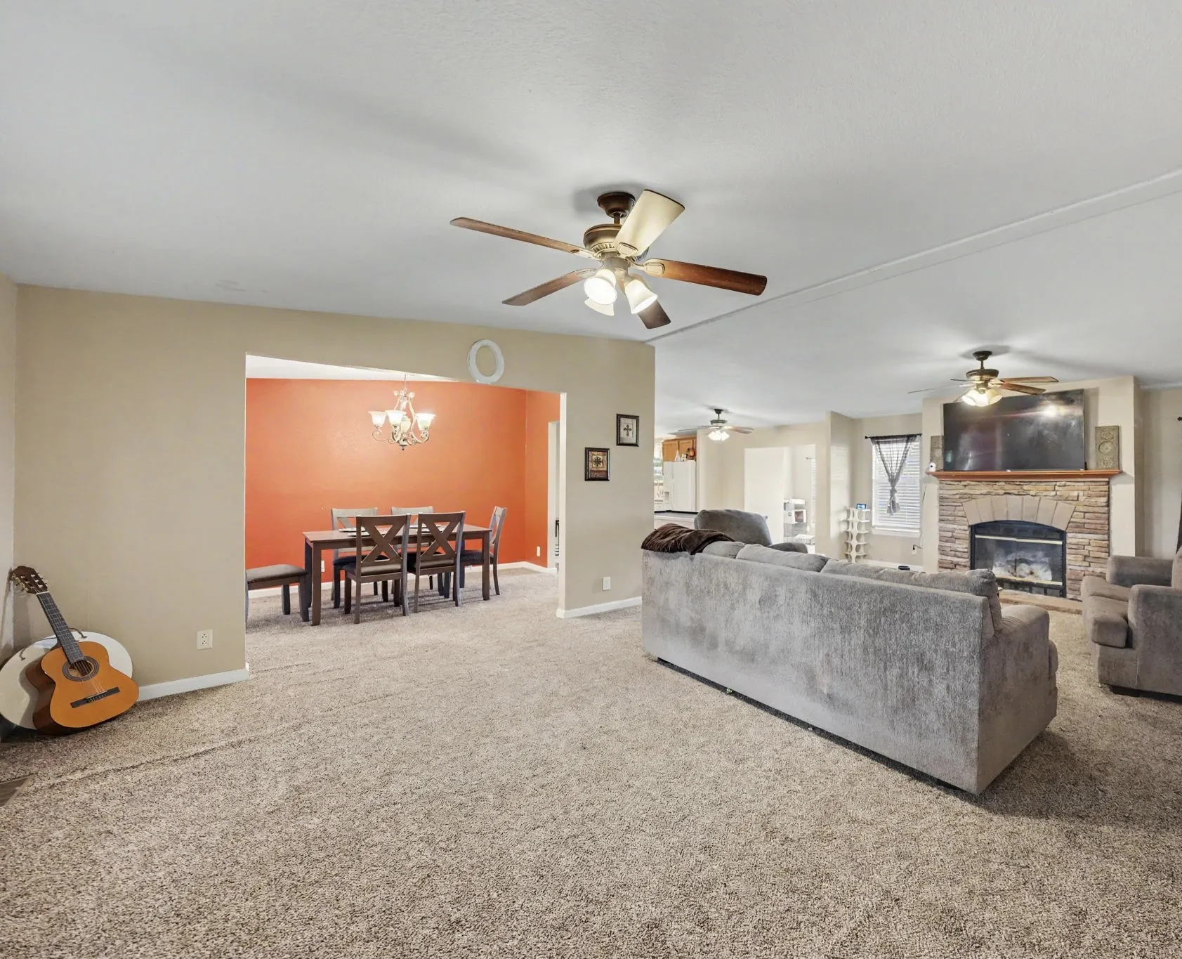 Spacious living room with a fireplace, flowing seamlessly into the kitchen and dining area.
