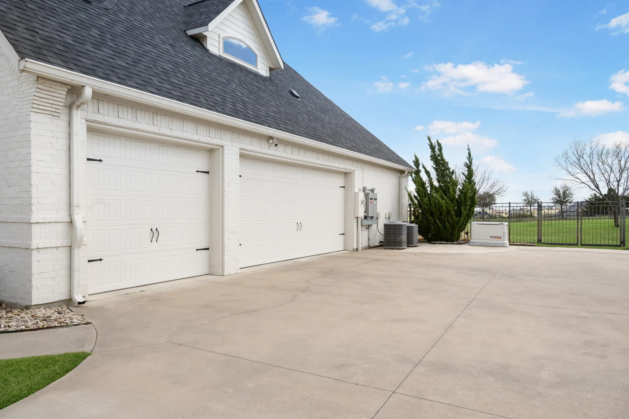 Two-car garage with white paneled doors and black hardware