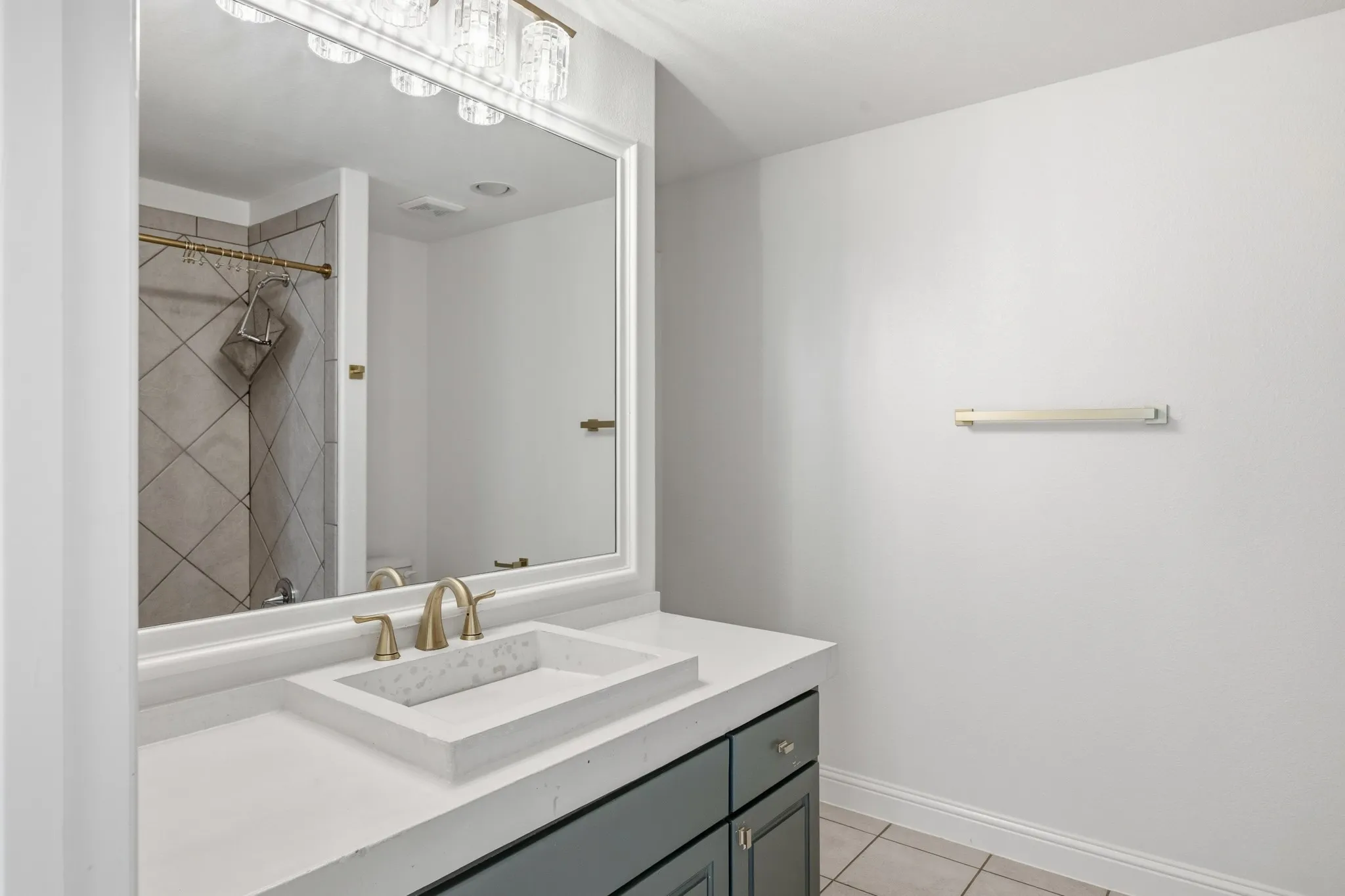 Modern vanity with a rectangular vessel sink, gold-finish faucet, and coordinating hardware