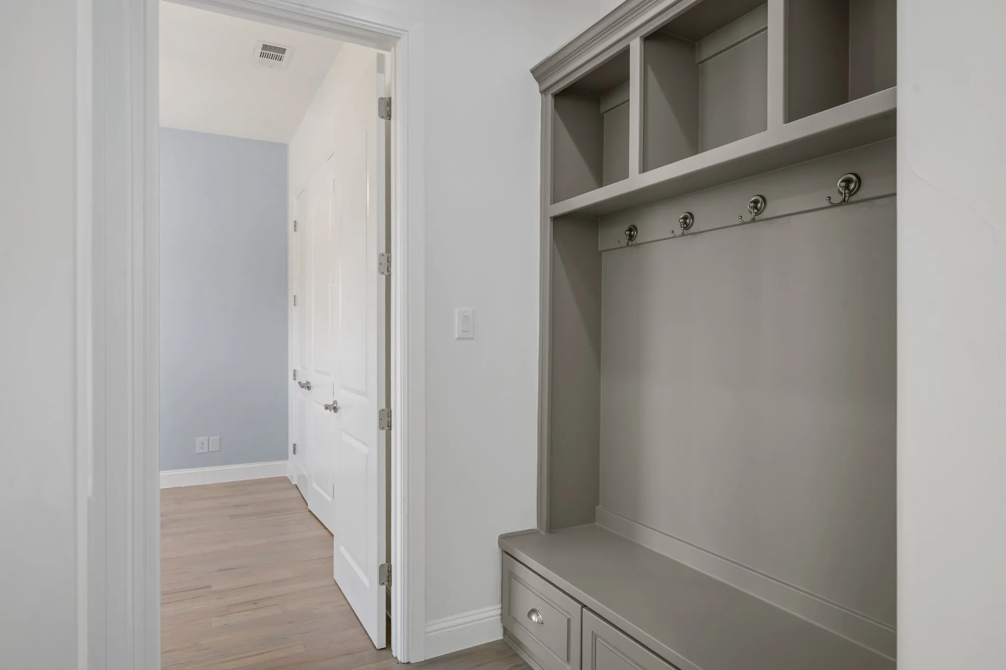 Built-in storage bench with drawers, integrated shelving, and coat hooks