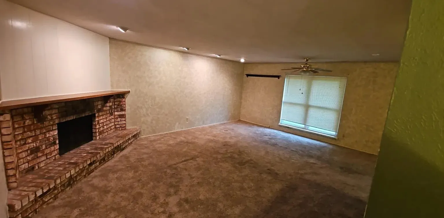 Brick fireplace with a wood-finish mantel and hearth, recessed lighting, ceiling fan, and window with blinds