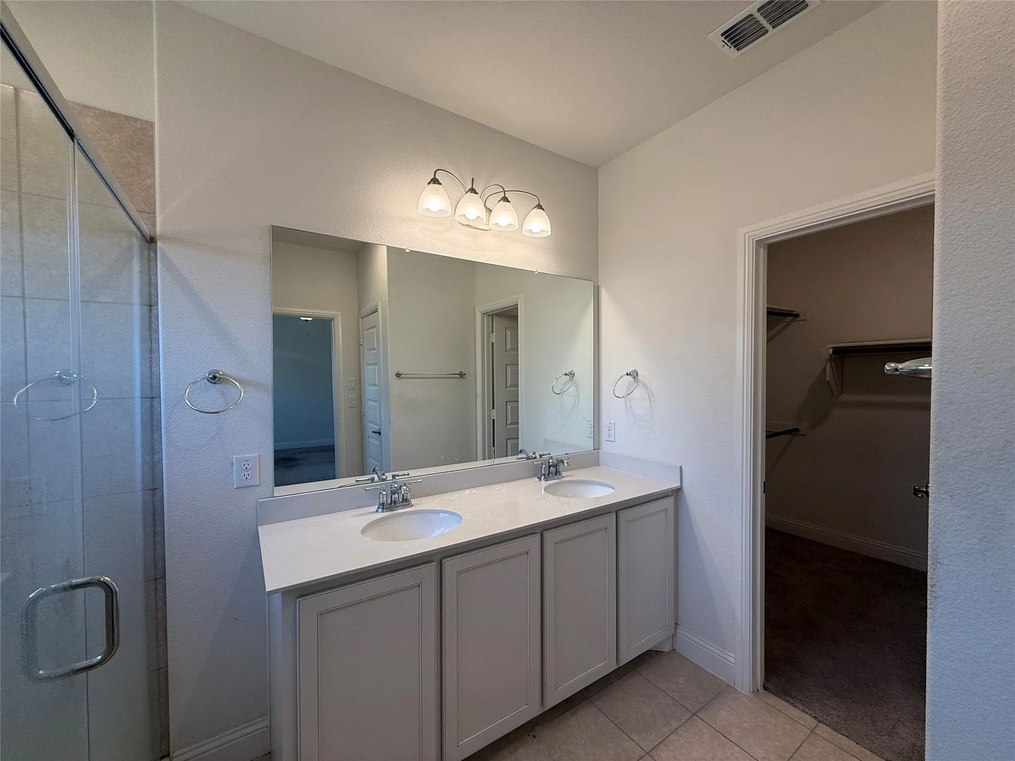 Dual vanity with undermount sinks, stone-finish countertop, and chrome fixtures