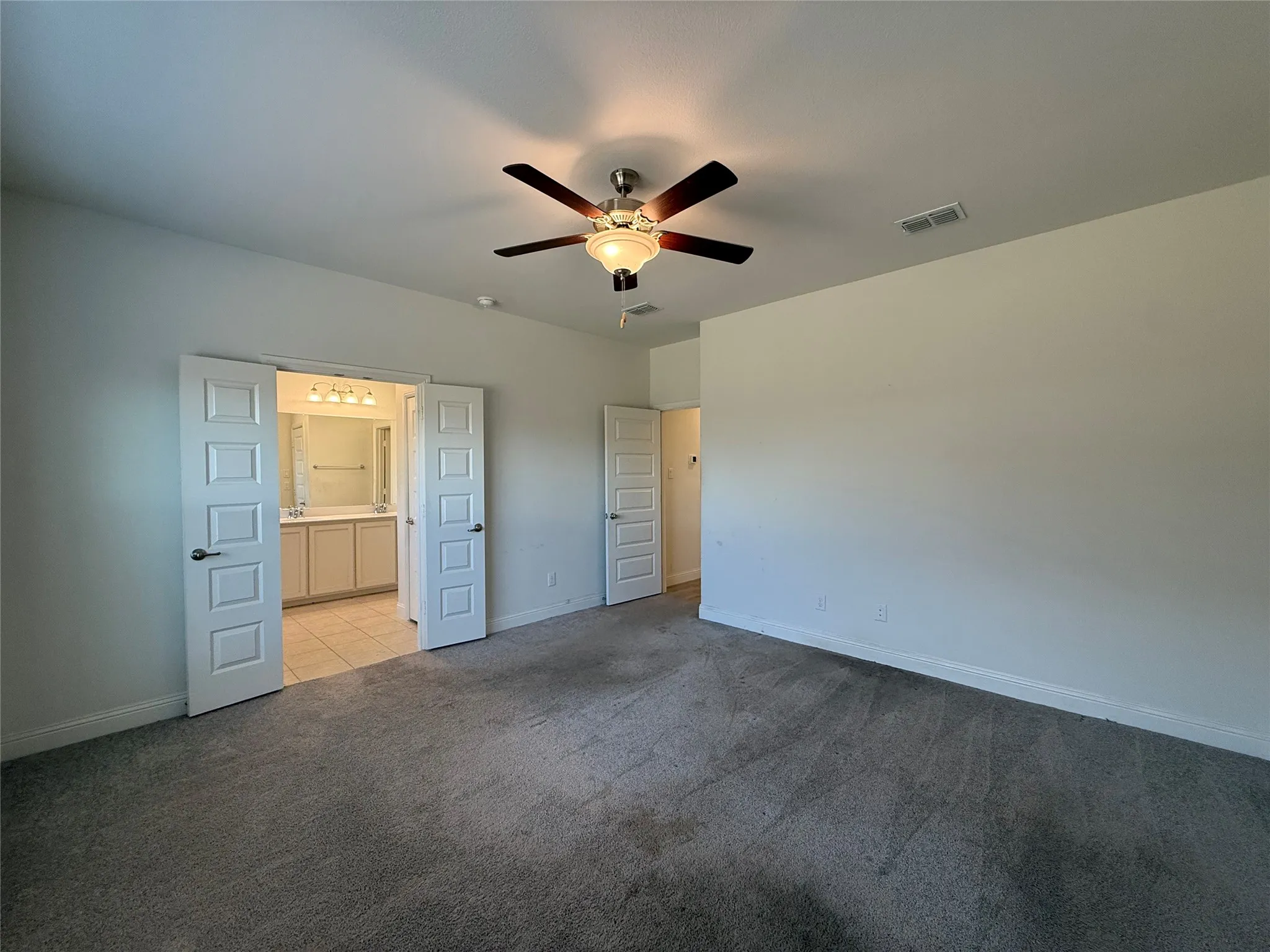 Carpeted room with a ceiling fan