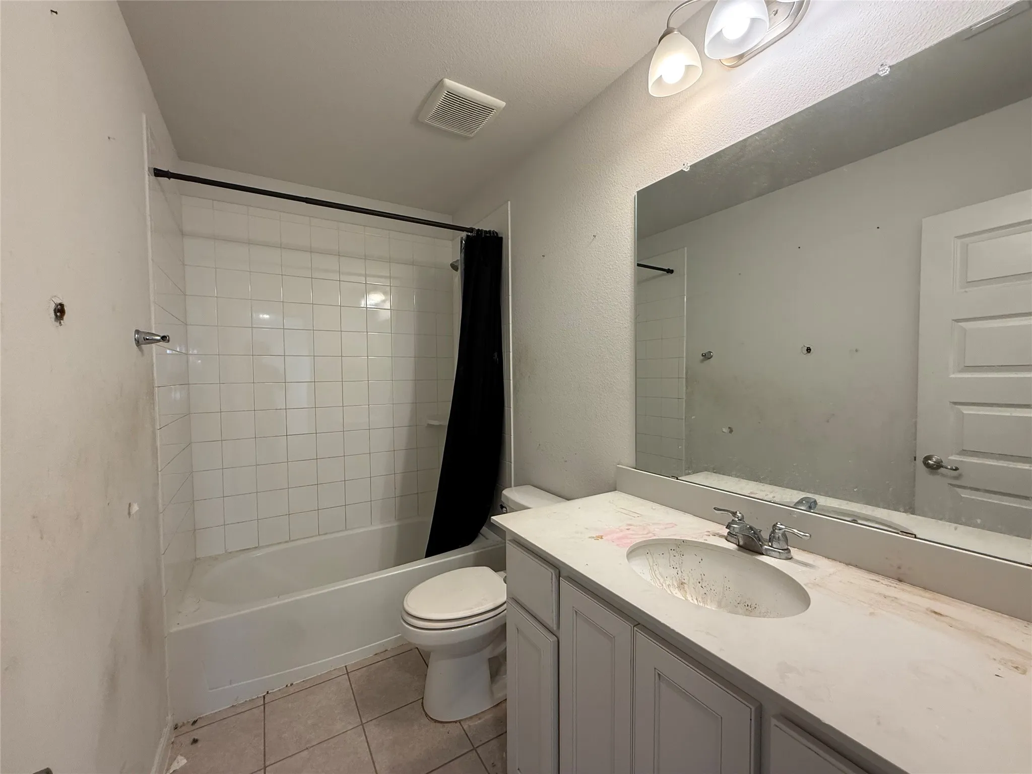 White tile shower surround with a tub, a vanity with an integrated sink, and a wall-mounted mirror