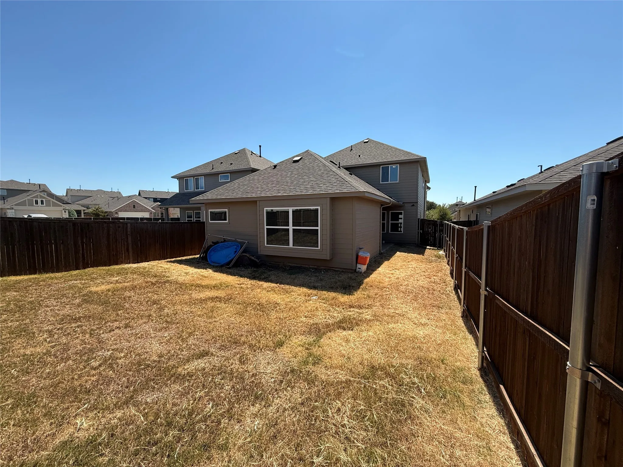 Fenced backyard with a side yard and wood fencing