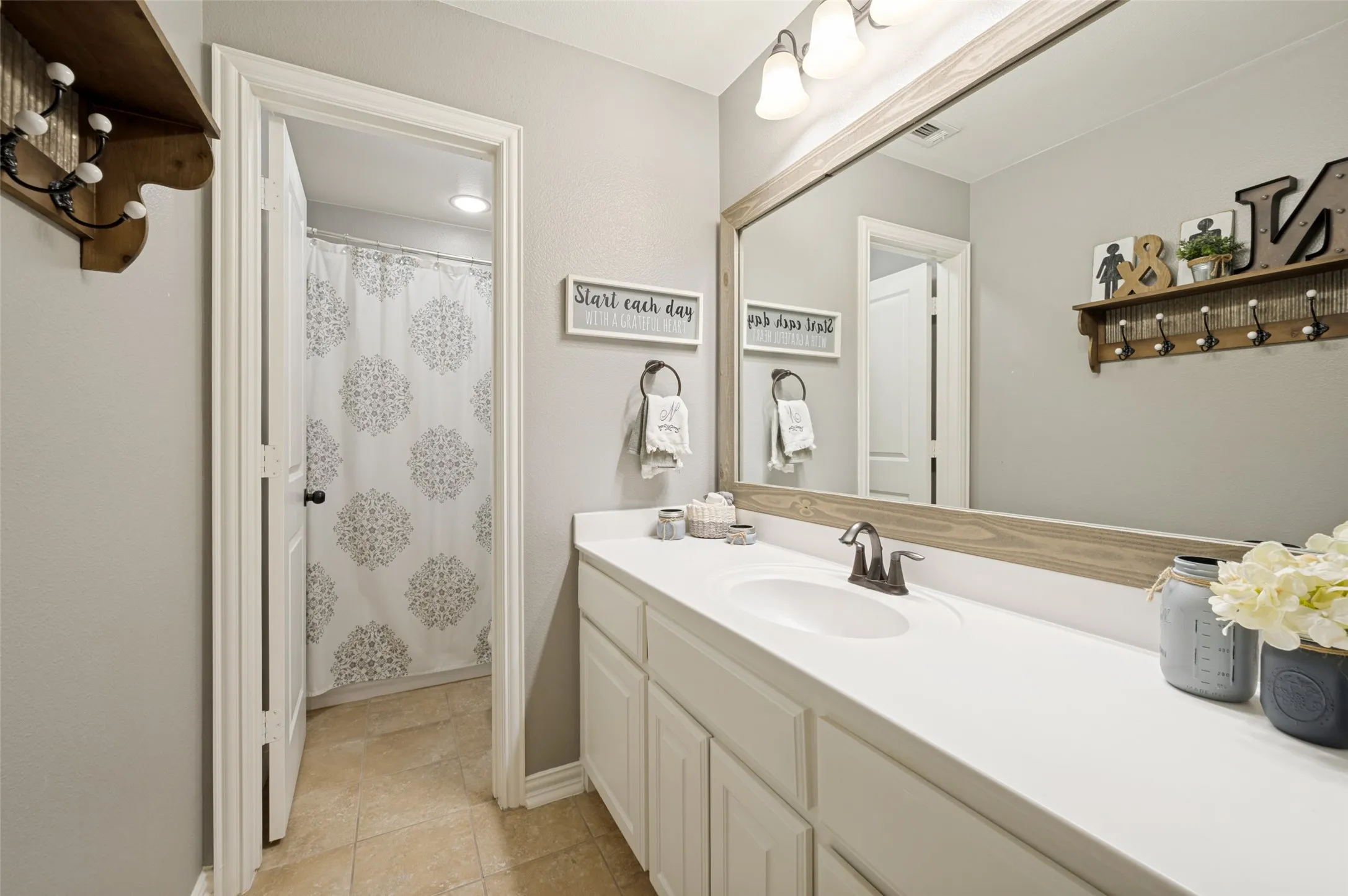 Secondary bathroom featuring a spacious vanity with ample countertop space and a convenient shower/tub combination, perfect for family or guests.