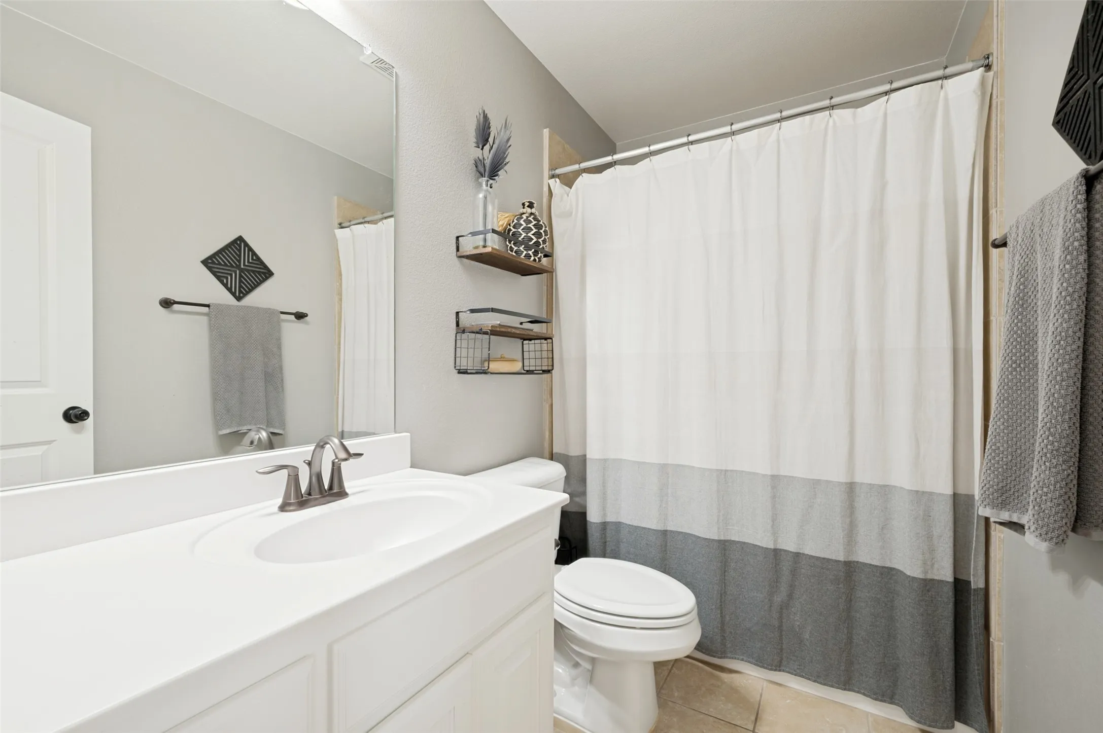 Well-appointed secondary bathroom featuring a spacious vanity with ample storage and a convenient shower/tub combination, providing the perfect blend of style and functionality for family and guests.
